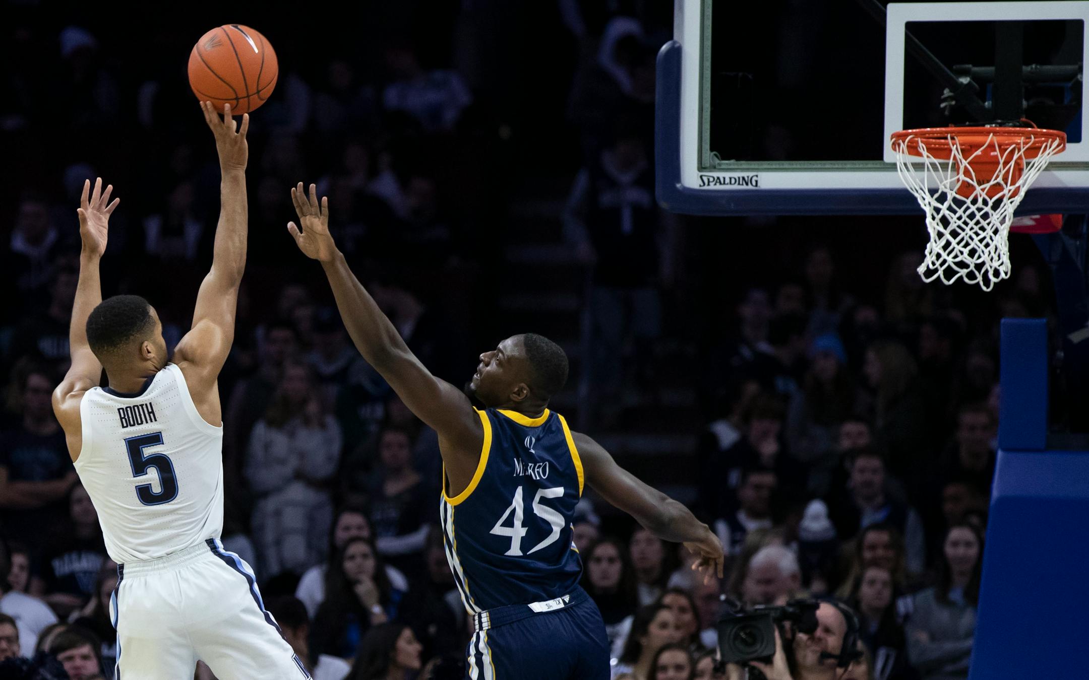 Villanova's Phil Booth, left, shoots over Quinnipiac's Kevin Marfo during the second half of an NCAA college basketball game Saturday, Nov. 10, 2018, in Philadelphia. (AP Photo/Chris Szagola)