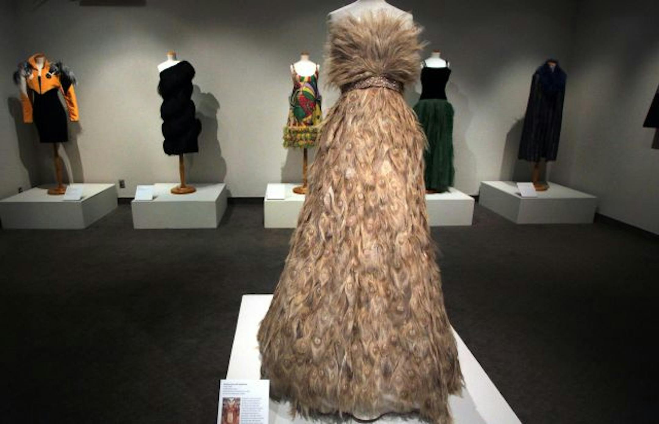 Among the items on display is a wedding dress with beaded belt (2009) crafted predominantly from bleached peacock feathers, on loan from Monique Lhuillier.