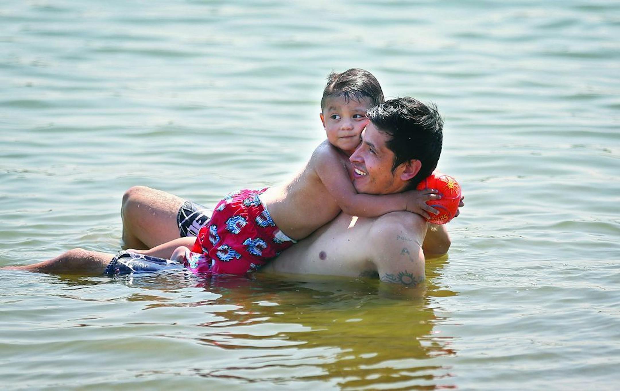 Jose Noria, Minneapolis, enjoyed playing in the cool waters of Lake Nokomis on a hot, August afternoon with his son, Kaled, 2.