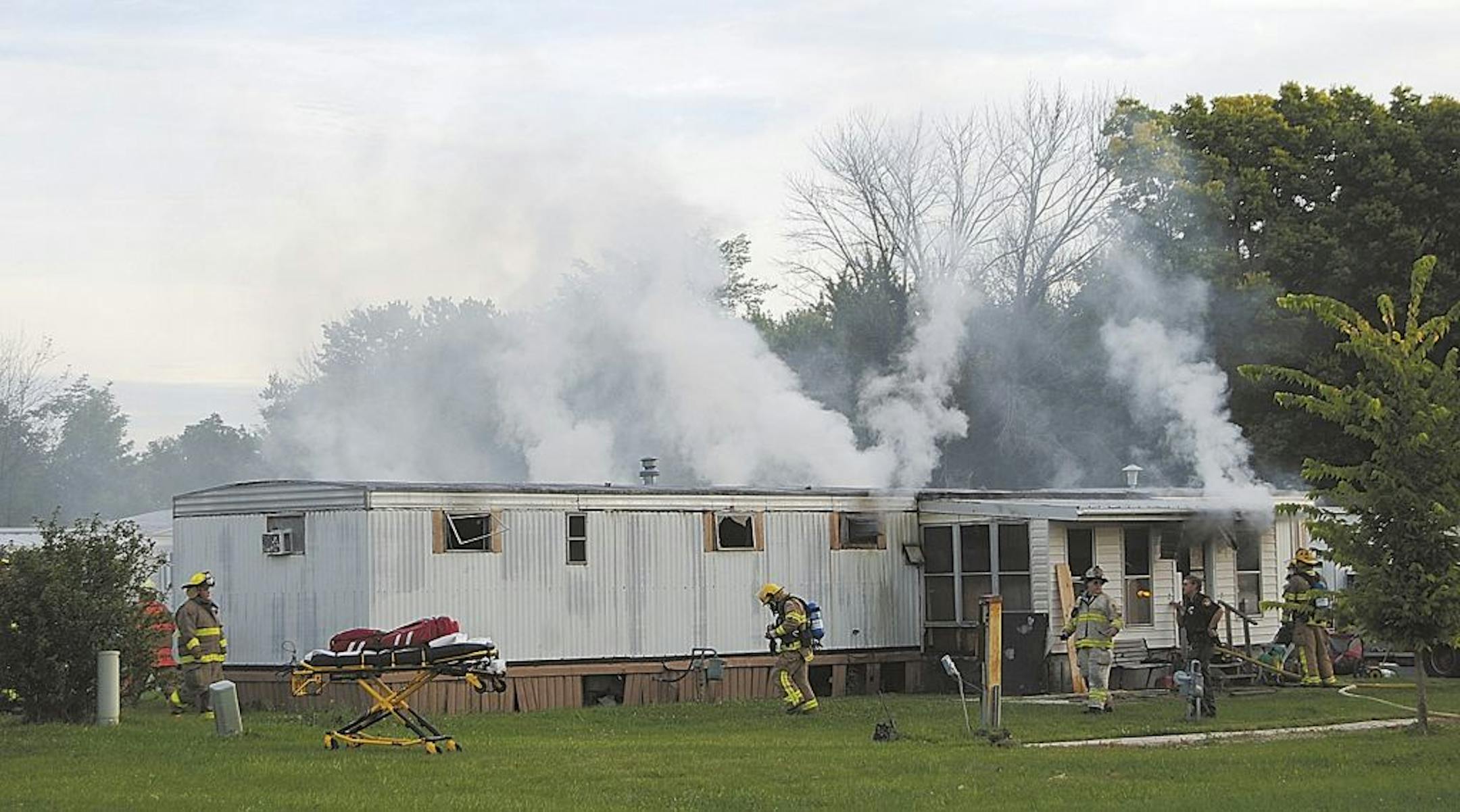 Firefighters extinguish a mobile home fire Sunday, Sept. 15, 2013, that killed a man and five children in Tiffin, Ohio, according to police.
