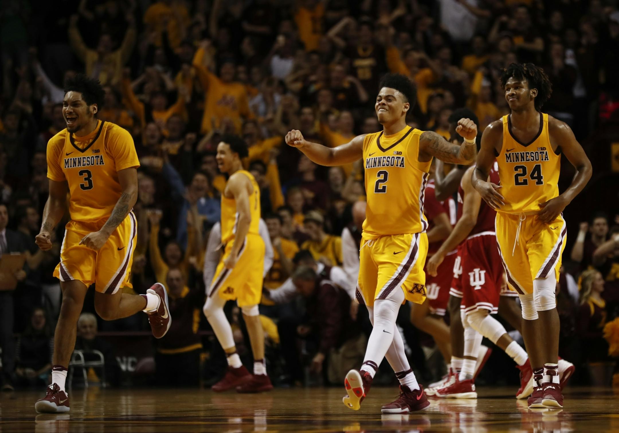 Gophers forward Jordan Murphy (3), Gophers guard Nate Mason (2), and Gophers forward Eric Curry (24) headed towards to celebrate with their teammates after pulling off a 75-74 win over Indiana.
