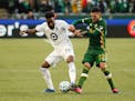 Minnesota United defender Romain Metanire, left, battles with Portland Timbers midfielder Cristhian Paredes, right, during the first half of an MLS so