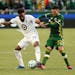 Minnesota United defender Romain Metanire, left, battles with Portland Timbers midfielder Cristhian Paredes, right, during the first half of an MLS so