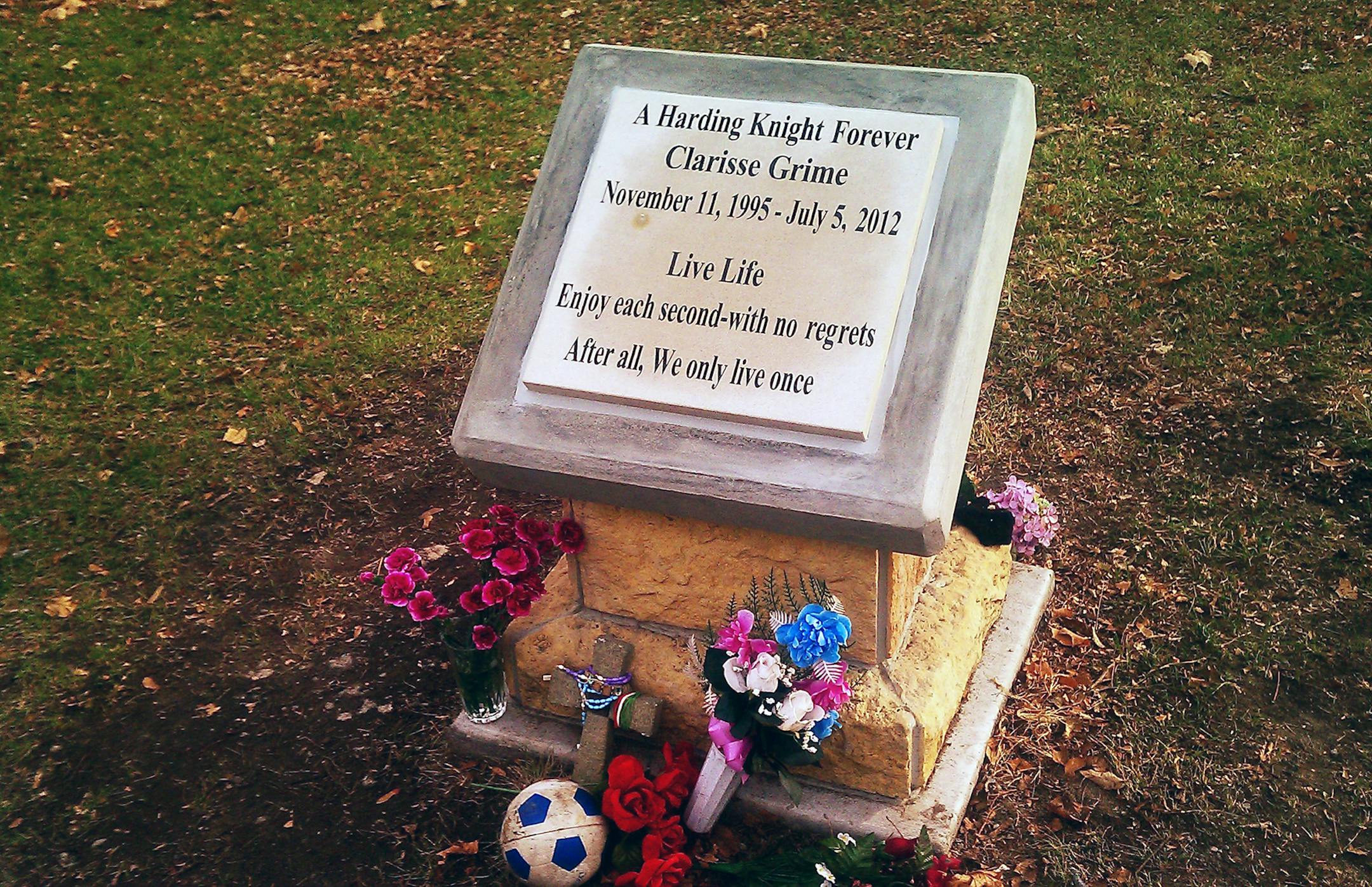 This memorial to Clarisse Grime stands outside Harding High School in St. Paul, near where she was killed. It reads "A Harding Knight Forever" and is adorned with flowers, a crucifix and a ball that people have left in memory of the 16-year-old.