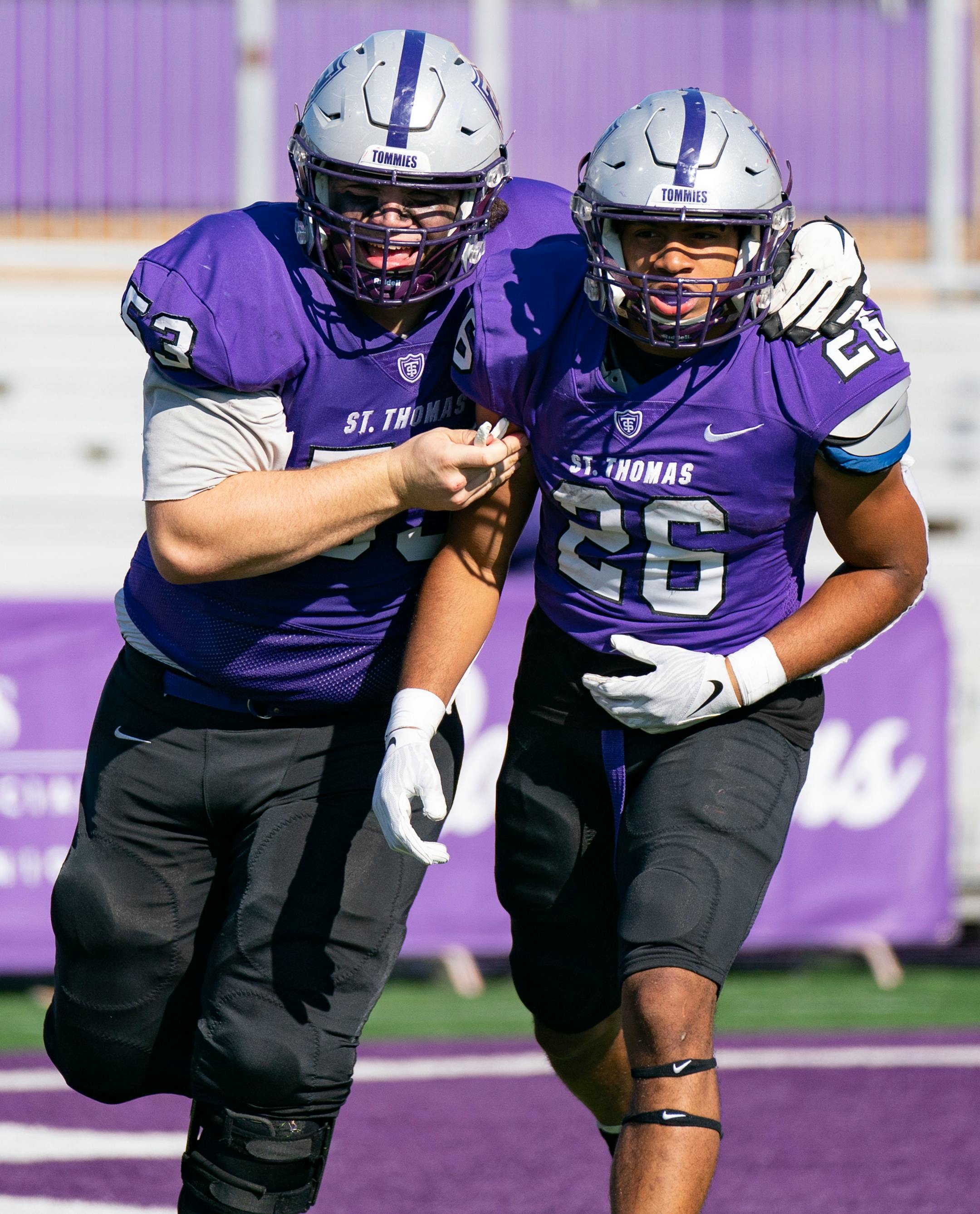 St. Thomas offensive lineman Matt Weimann (53) celebrates with running back Shawn Shipman (26) after he scored a 70-yard rushing touchdown.