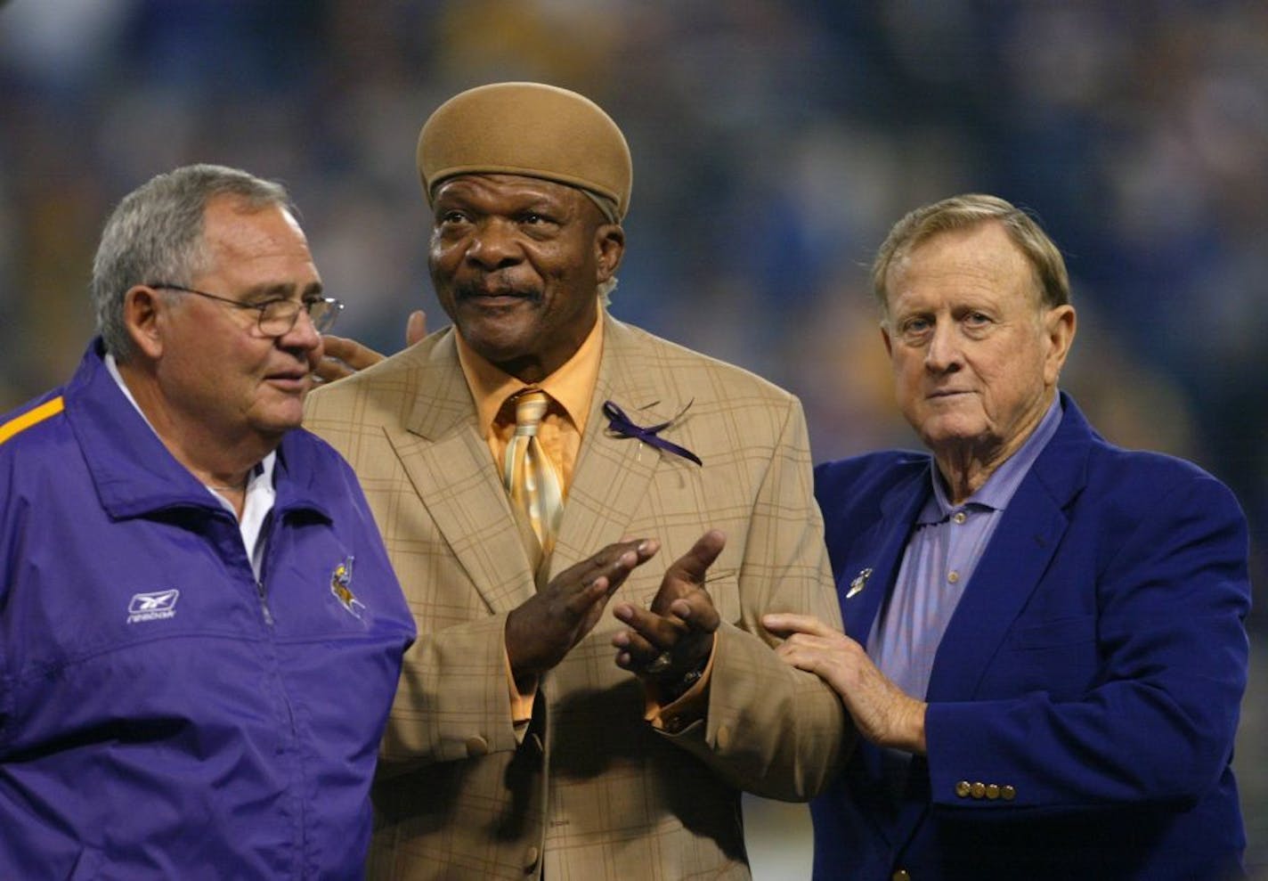 Vikings owner Red McCombs patting Carl Eller, center, on the back after McCombs introduced Eller's former coach, Bud Grant to the Metrodome crowd to talk about Eller as he was inducted into the Vikings Ring of Fame. At left is former trainer Fred Zamberletti, also a member of the ring. GENERAL INFORMATION: MINNEAPOLIS - 11/10/02 - The Vikings lost again on Sunday to the New York Giants 27 - 20 at the Metrodome.