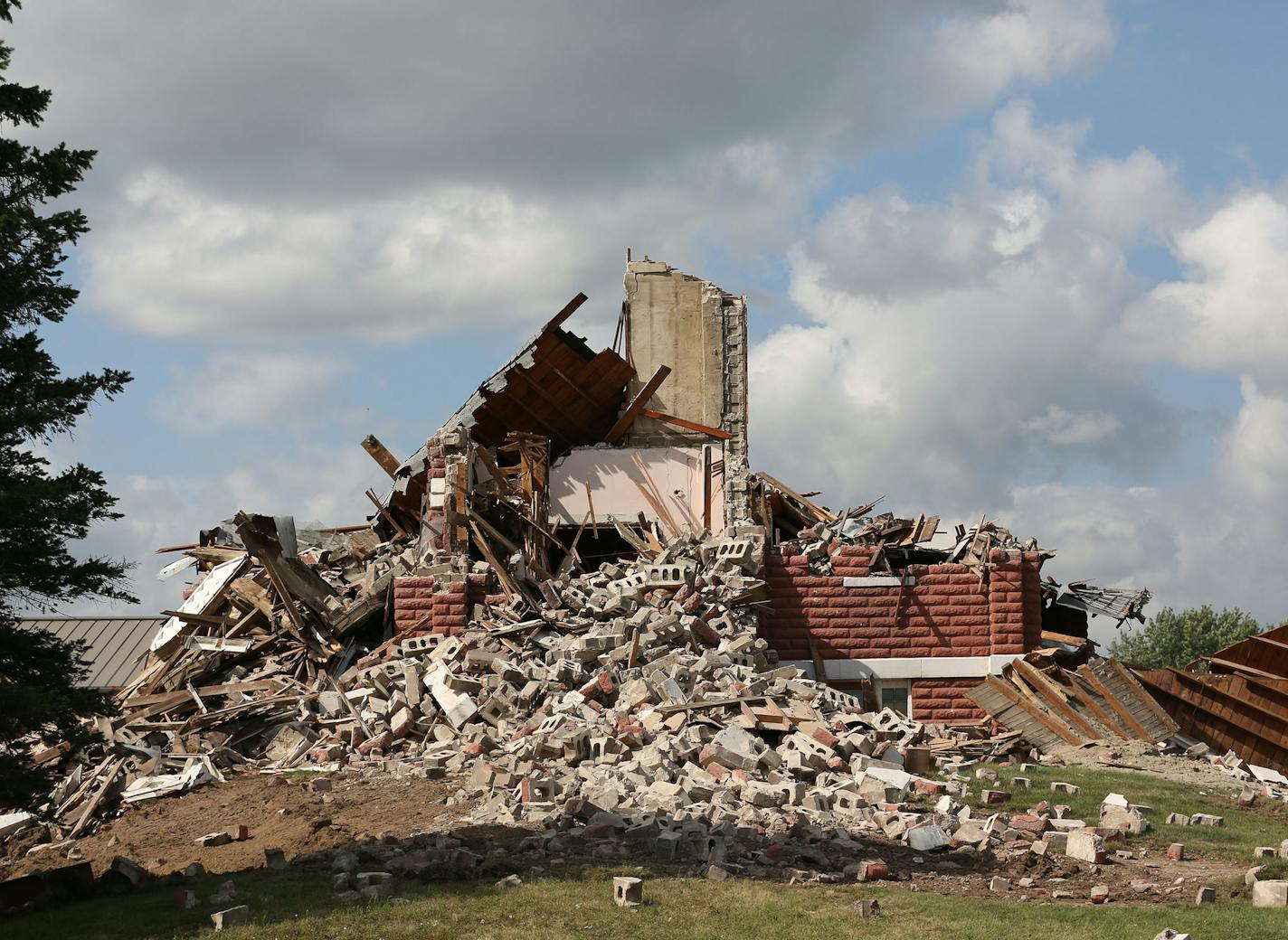 What was left of the Peace Lutheran Church as they continued with demolition. ] (KYNDELL HARKNESS/STAR TRIBUNE) kyndell.harkness@startribune.com During the demolition of Peace Lutheran Church in Baldwin Wis. Friday, August, 15, 2014. Plans for solving some of the issues that the109 year old church had had been in the works since 2005 said Pastor John Anderson, who had been there for 22 years. He said that the membership had voted to stay together and couldn't afford the expense of saving the str