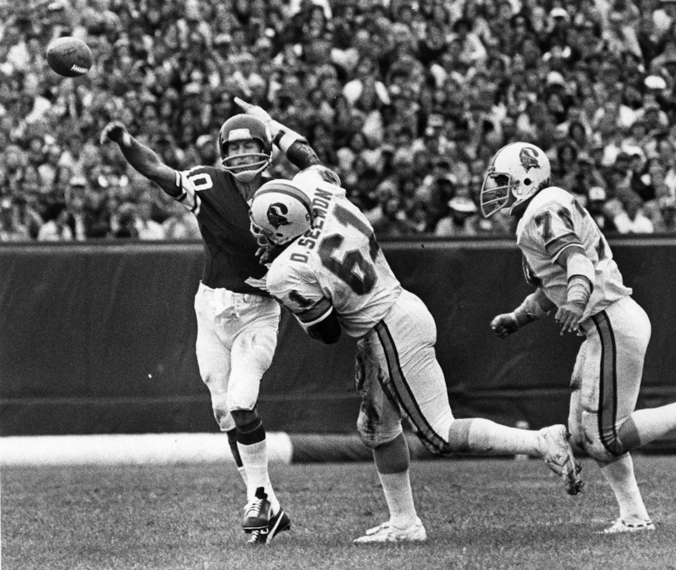 Fran Tarkenton got the ball away as Tampa Bay's Dewey Selmon put on the pressure during a 1978 game. It was the 38-year-old Tarkenton's last season. He threw 25 TD passes that year, but also 32 interceptions. Tommy Kramer took over the next year.