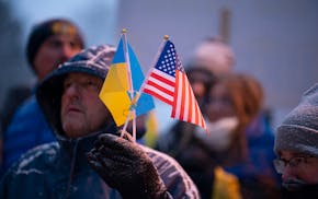 Julian Pishko holds Ukrainian and American flags while attending a rally in Minneapolis on Feb. 24, 2022.