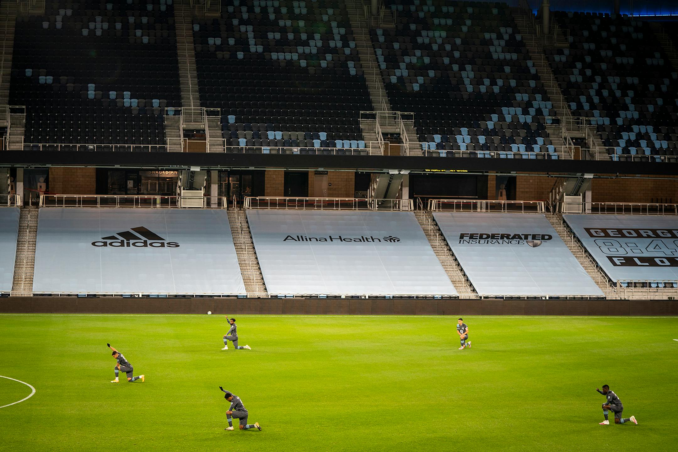 Minnesota United players kneeled and raised their fists at the beginning of the game in an empty stadium.