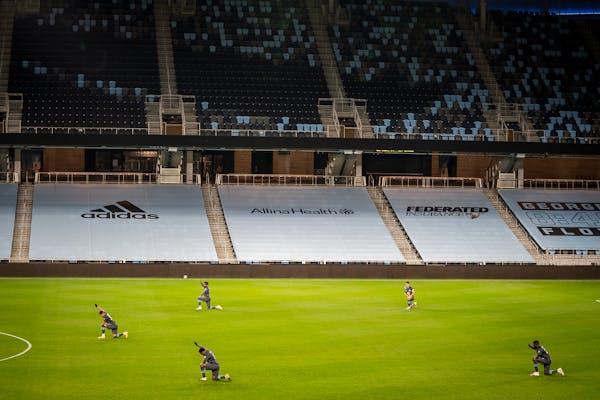 Minnesota United players kneeled and raised their fists at the beginning of the game in an empty stadium.