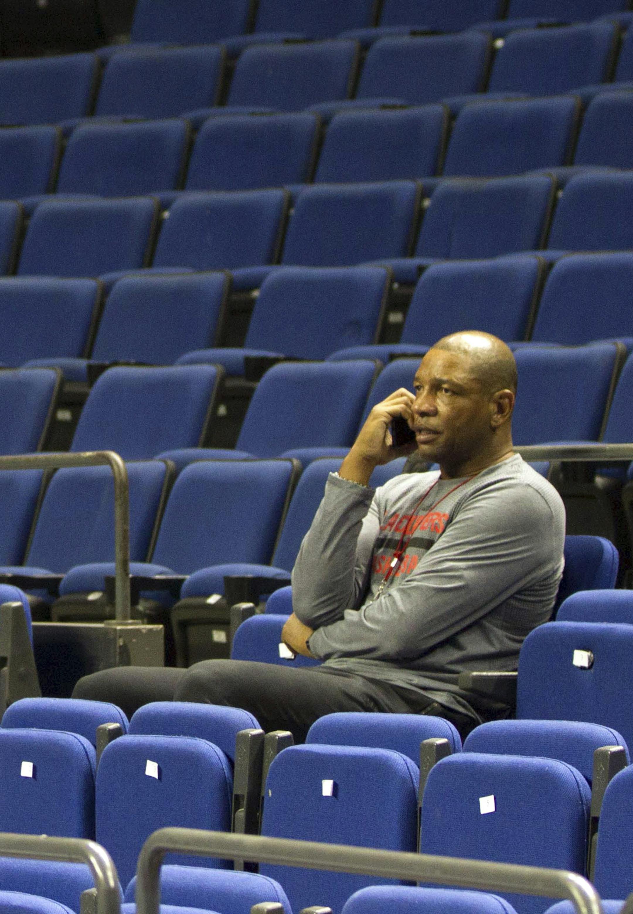 Los Angeles Clippers head coach Doc Rivers sits in the stands during a practice session in Shanghai, China Tuesday, Oct. 13, 2015. The Los Angeles Clippers and the Charlotte Hornets will play a preseason game in Shanghai on Wednesday as part of the 2015 NBA Global Games. (Chinatopix via AP) CHINA OUT ORG XMIT: MIN2015103017534757