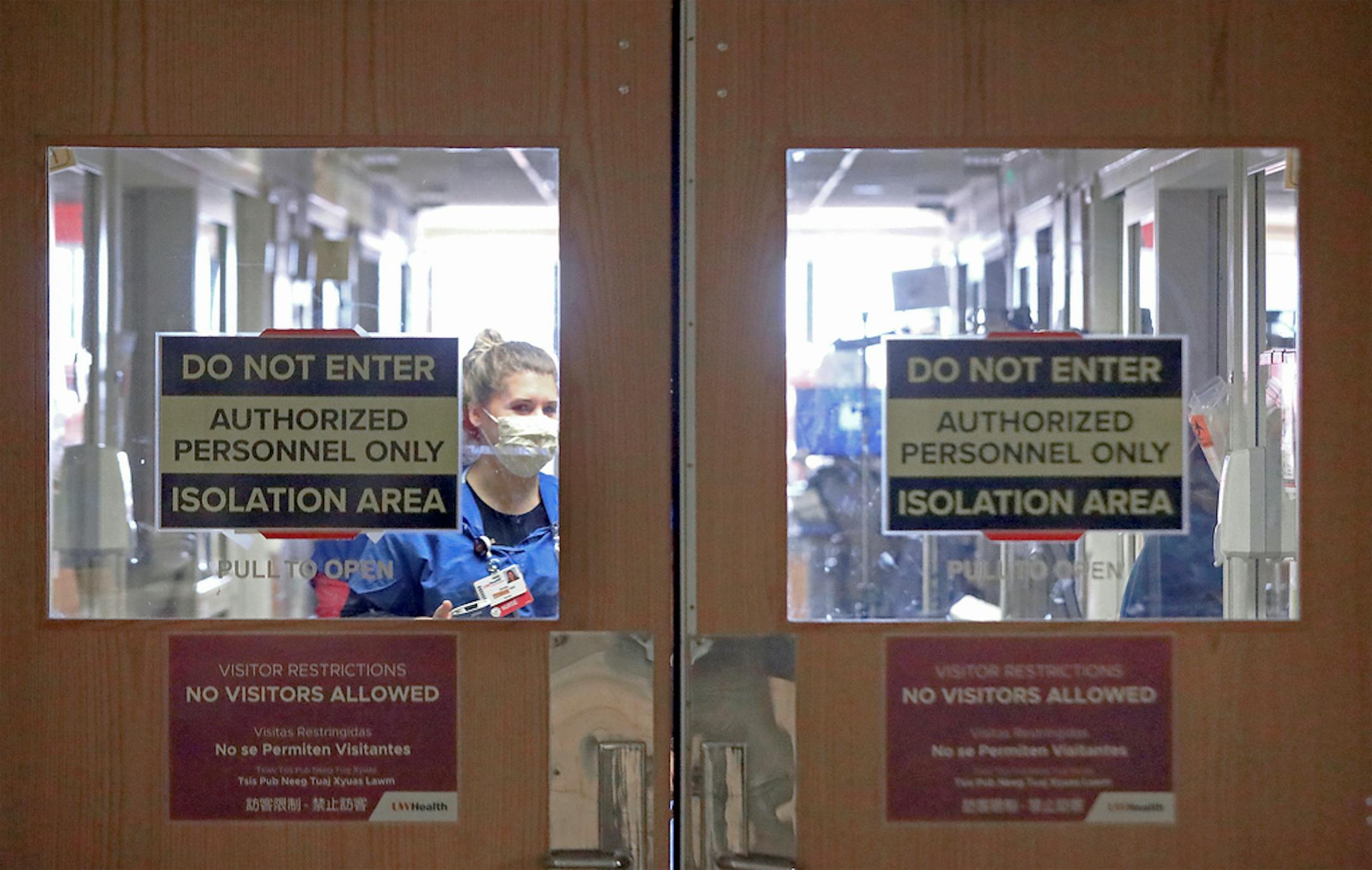 Doors to a COVID-19 treatment unit at UW Health in Madison, Wis. caution hospital personnel and visitors Thursday, Nov. 5, 2020. Until recently, the hospital had four wings for coronavirus patients. To meet growing demand, it added another wing. (John Hart/Wisconsin State Journal via AP)