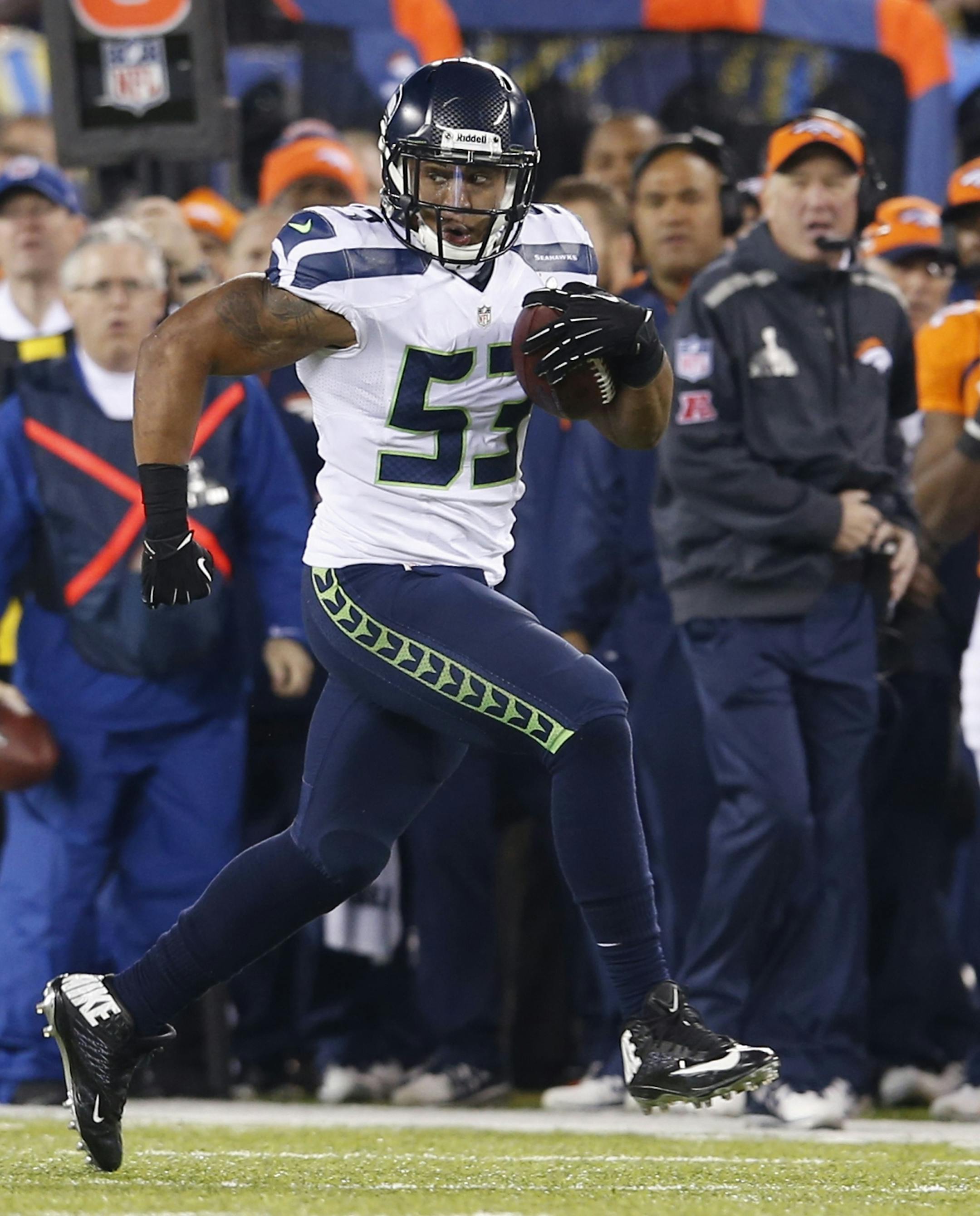 Seattle Seahawks' Malcolm Smith (53) returns an interception 69-yards for a touchdown during the first half of the NFL Super Bowl XLVIII football game against the Denver Broncos Sunday, Feb. 2, 2014, in East Rutherford, N.J.(AP Photo/Evan Vucci)