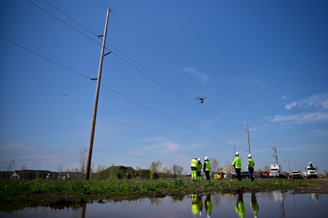 A crew launches a drone to install a “Magic Orb” on a power line on April 30 in Maple Grove.