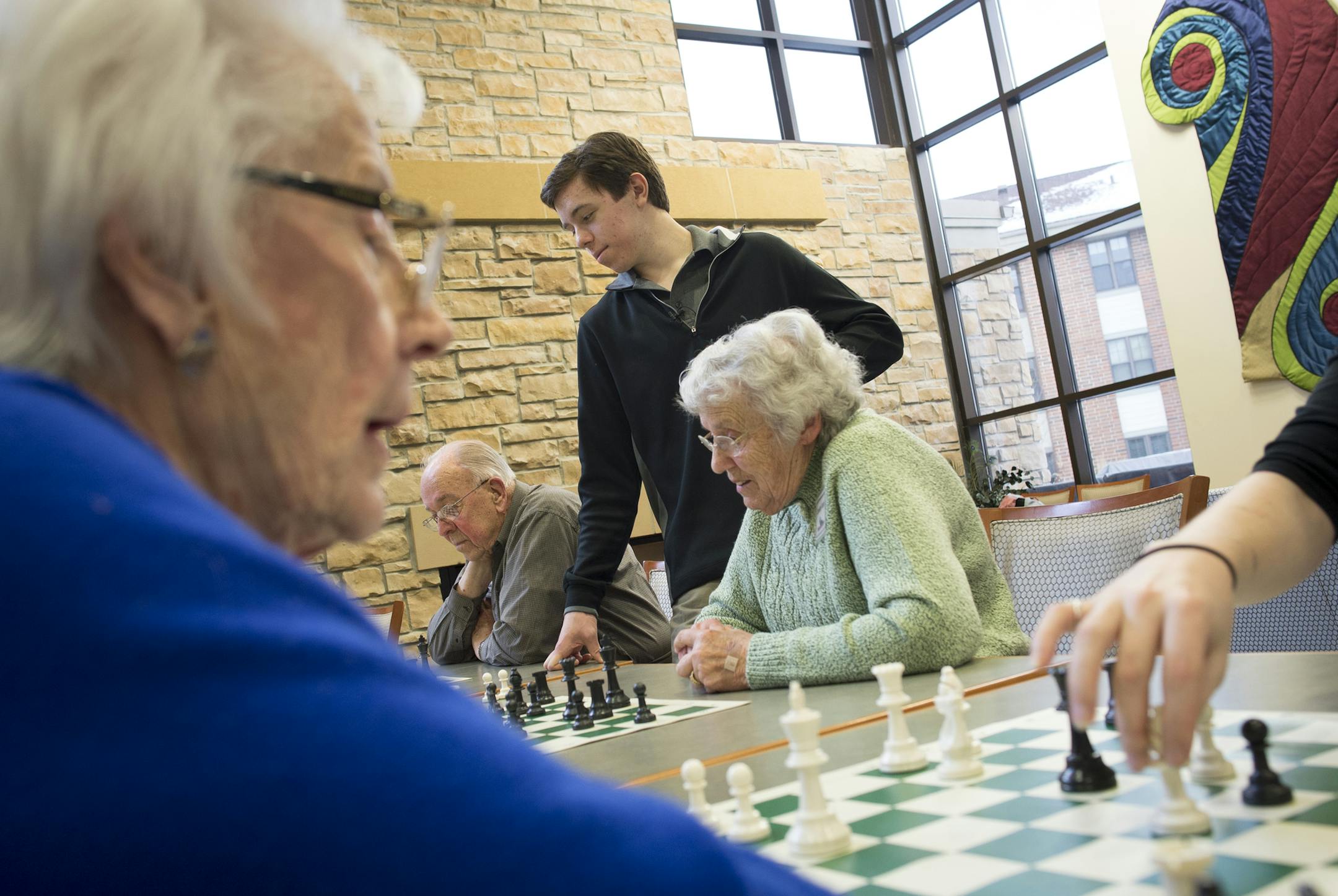 Connor Quinn, center, watches as some of his students, senior residents of Friendship Village, play chess during his class on Tuesday afternoon. ] (Aaron Lavinsky | StarTribune) Elderly residents of Friendship Village of Bloomington are learning chess from 17-year-old kid. Connor Quinn,a junior at The Blake School and a chess expert, who last year, placed 30th at the U.S. Chess Federation National High School Chess Tournament.After Connor's grandfather died last year, he wanted to spend more tim