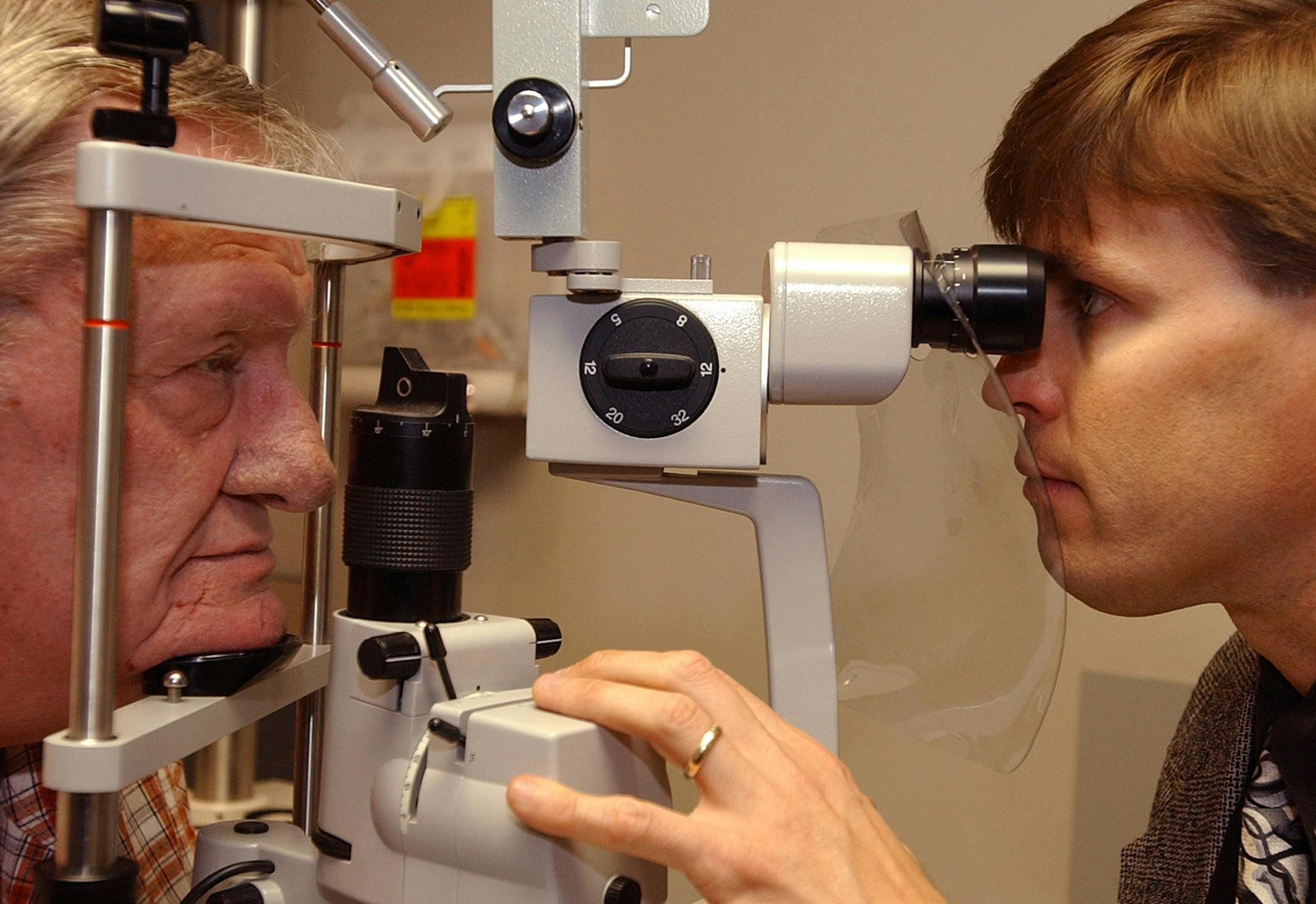 Dr. John O. Mason III, a University of Alabama Birmingham opthalmologist, examines a patient Tuesday Oct. 3, 2006, in Birmingham, Ala. Billy Lawley, left was recently injected with new medications that effectively reverse macular degeneration. Articles published in the New England Journal of Medicine on Thursday affirm the new treatment can restore sight with injections of either of two closely related drugs, Avastin and Lucentis, both monoclonal antibodies marketed by the pharmaceutical giant G