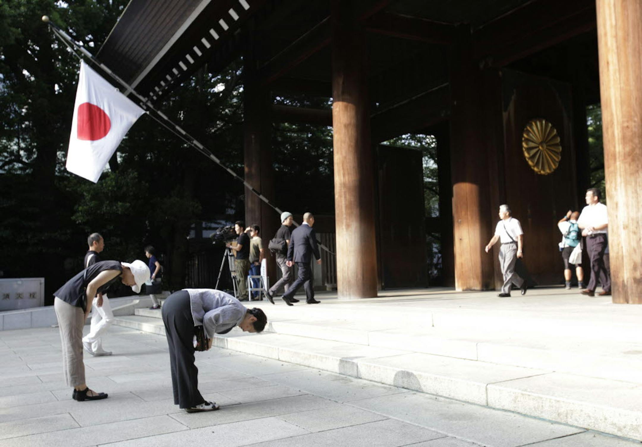 Worshippers bow deeply at the Yasukuni Shrine in Tokyo Thursday. Japan marked the 68th anniversary of its surrender in World War II with somber ceremonies Thursday and visits by senior politicians to the shrine honoring 2.5 million war dead.