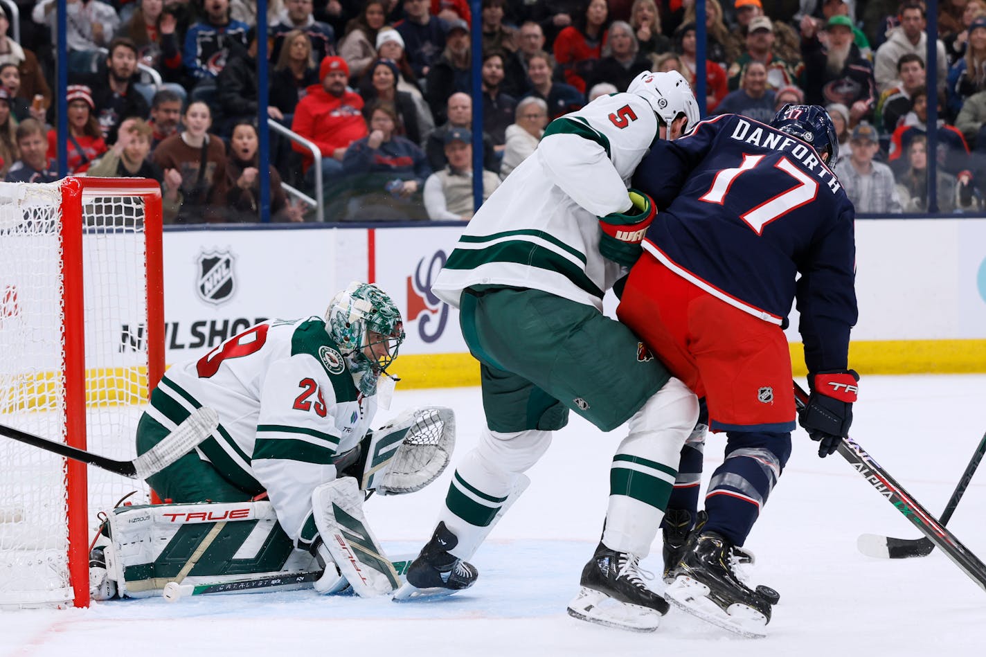 The Wild's Marc-Andre Fleury protected the net as Jake Middleton, center, and the Blue Jackets' Justin Danforth fought for the puck during the second period Saturday.