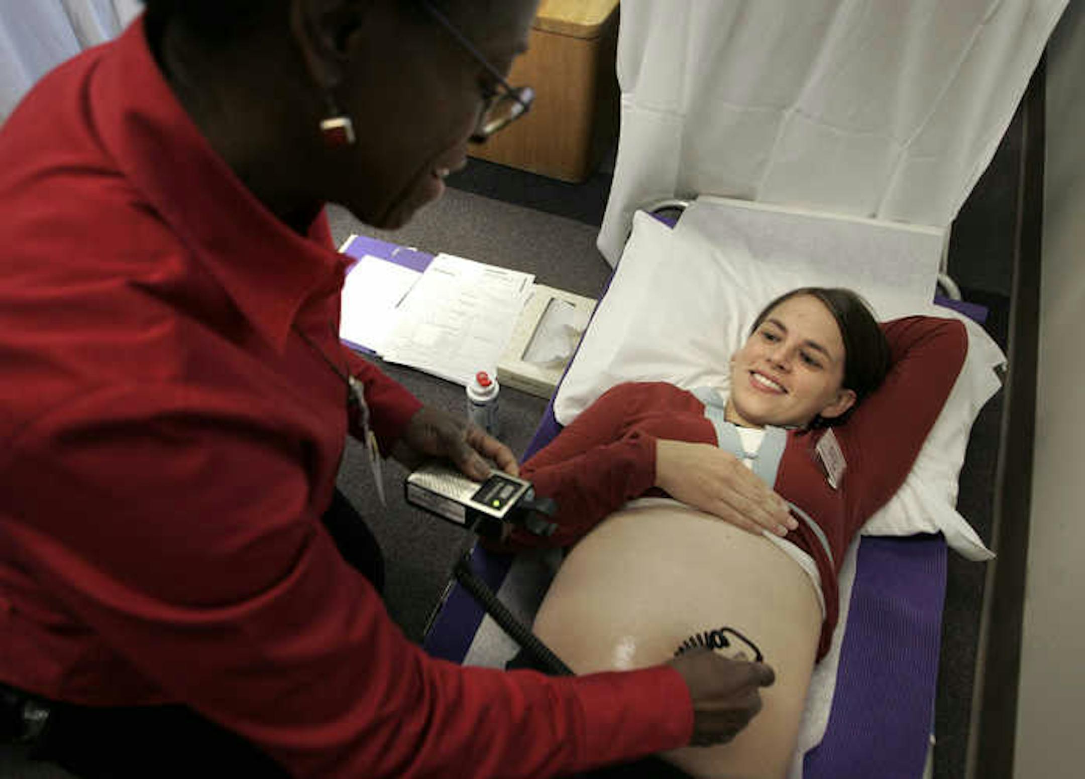 Jen Lindwall, 25, smiled at the sound of her babys heartbeat as midwife Vida Kent performed an exam on her during a Centering Pregnancy session.
