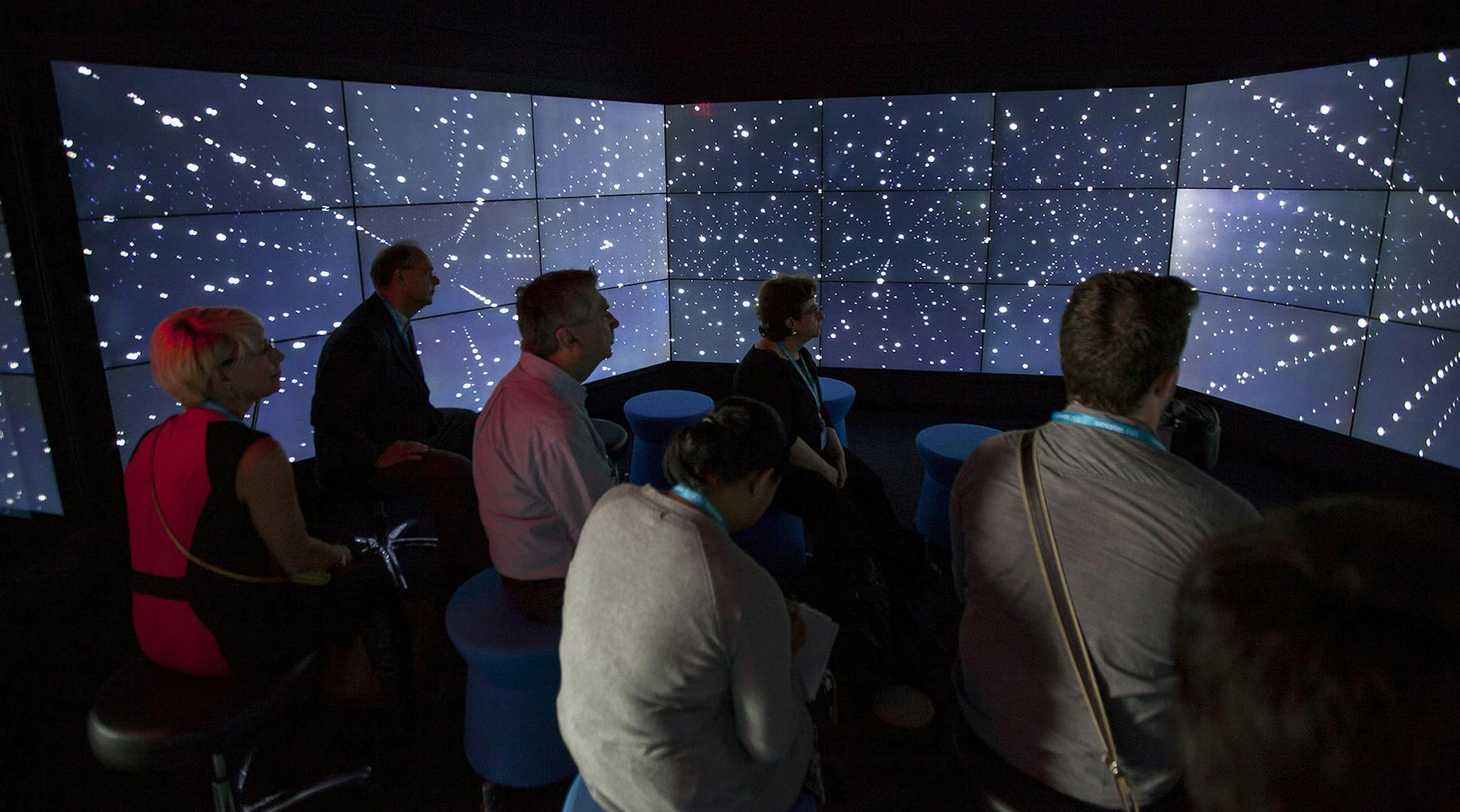 Attendees tour the International Business Machines Corp. (IBM) Watson immersion room during an event at the company's headquarters in New York, U.S., on Tuesday, Oct. 7, 2014. To help commercialize the technology famous for beating humans on the "Jeopardy!" game show, new languages such as Portuguese and Japanese are being added to the Watson service this year, said Stephen Gold, vice president of the Watson Group business. Photographer: Michael Nagle/Bloomberg ORG XMIT: 517515023