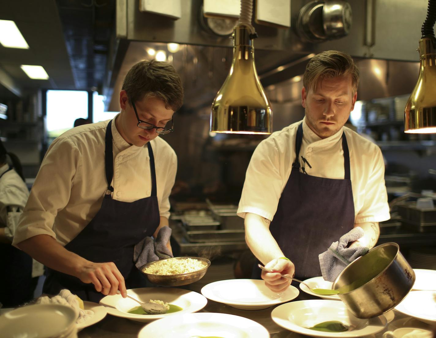 Bachelor Farmer sous chef Sam Miller and line cook Banle Gaar, left, plated entrees in the busy kitchen Monday night. ] JEFF WHEELER &#x2022; jeff.wheeler@startribune.com Bachelor Farmer's Paul Berglund won the Best Chef Midwest award from the James Beard Foundation Monday night. While he was collecting his medal at an awards ceremony in Chicago, his staff was having a very busy night in the kitchen, though they did live stream the the awards on a laptop Monday night, May 2, 2106 in Minneapolis.