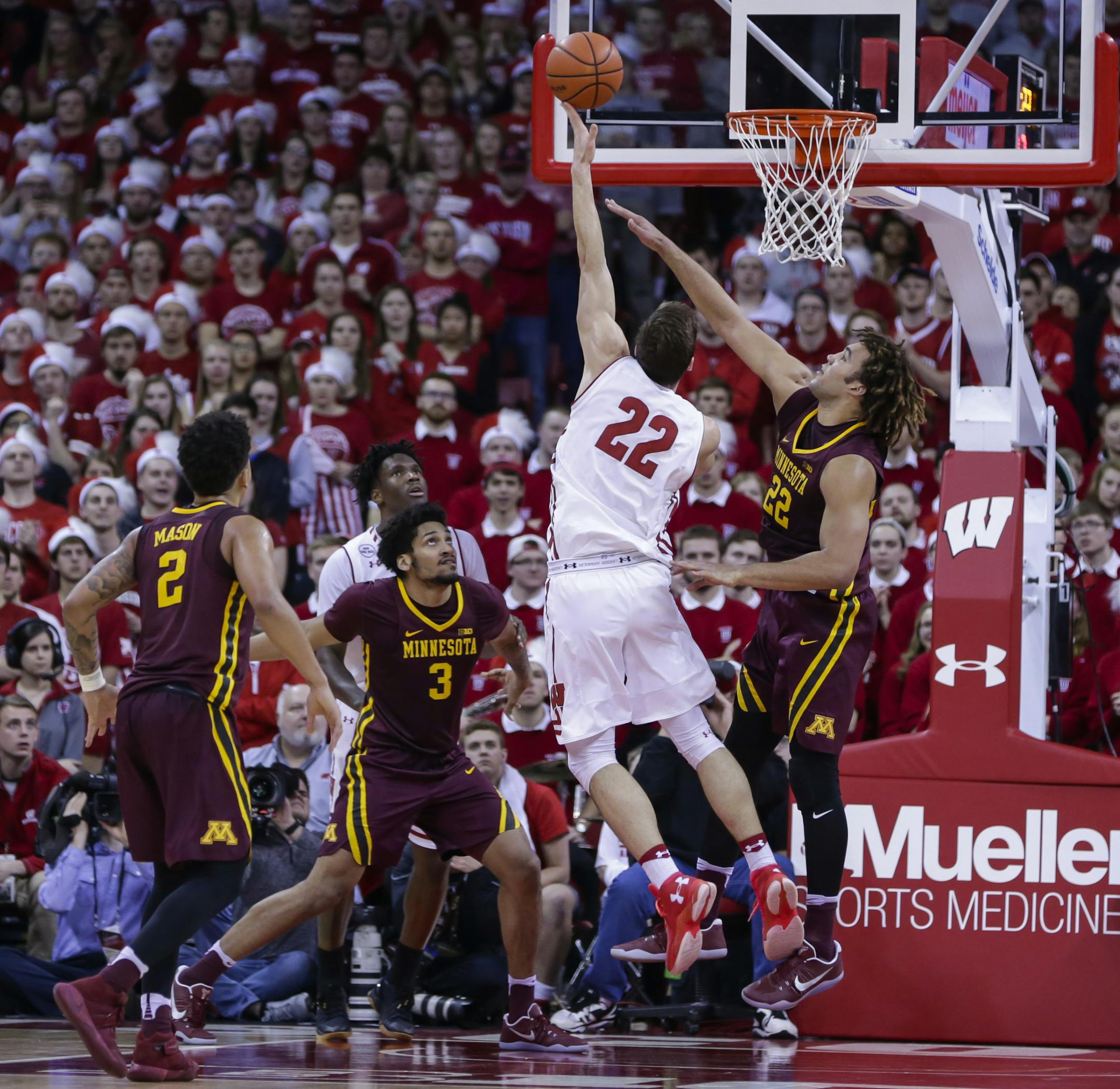 Wisconsin's Ethan Happ (22) shoots agisngt Minnesota's Reggie Lynch during the first half of an NCAA college basketball game Sunday, March 5, 2017, in Madison, Wis. (AP Photo/Andy Manis)