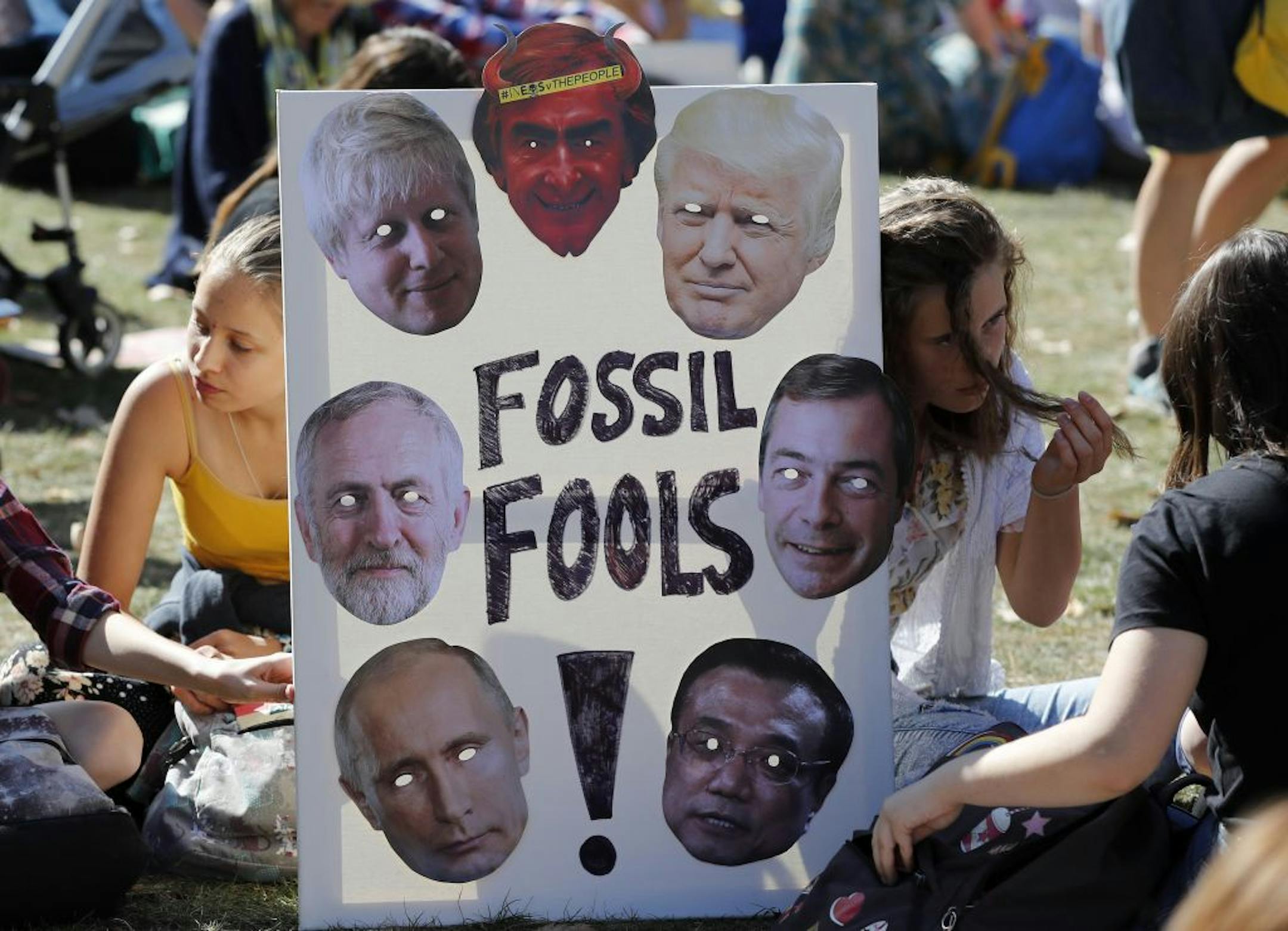Climate protesters hold a banner bearing the images of world leaders as they demonstrate in London, Friday, Sept. 20, 2019. Protesters around the world joined rallies on Friday as a day of worldwide demonstrations calling for action against climate change began ahead of a U.N. summit in New York.