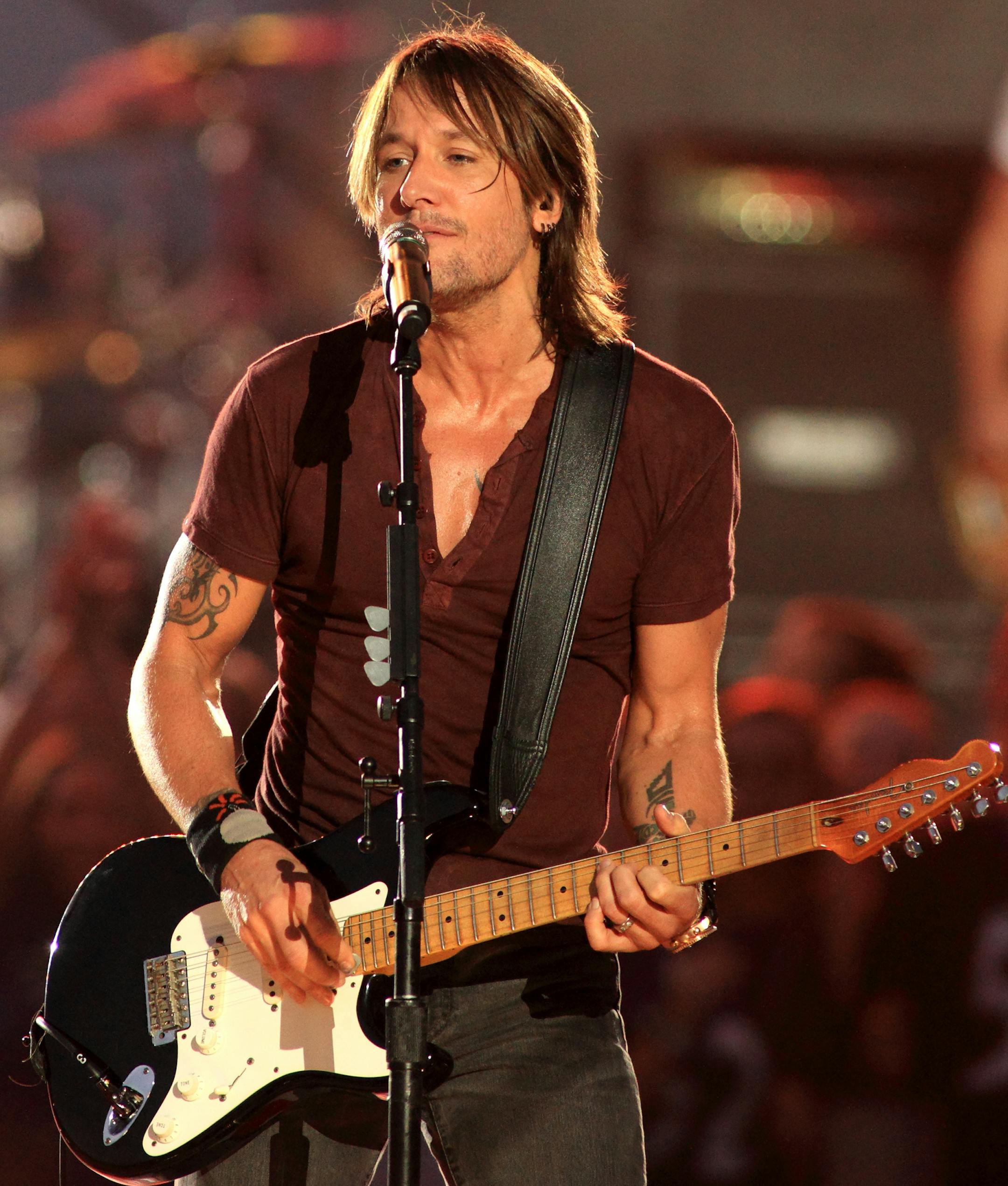 FILE - In this Sept. 5, 2013 file photo, country music artist Keith Urban performs in concert during the NFL football Kickoff 2013 at the Inner Harbor in Baltimore. Lorde joins Macklemore & Ryan Lewis for "The Grammy Nominations Concert Live!! _ Countdown to Music's Biggest Night,&#xee; to be held on Dec. 6, 2013, at the Nokia Theatre L.A. Live. Urban will take the stage with R&B singer Miguel to sing Bill Withers&#xed; &#xec;Ain&#xed;t No Sunshine.&#xee; (Photo by Owen Sweeney/Invision/AP, File