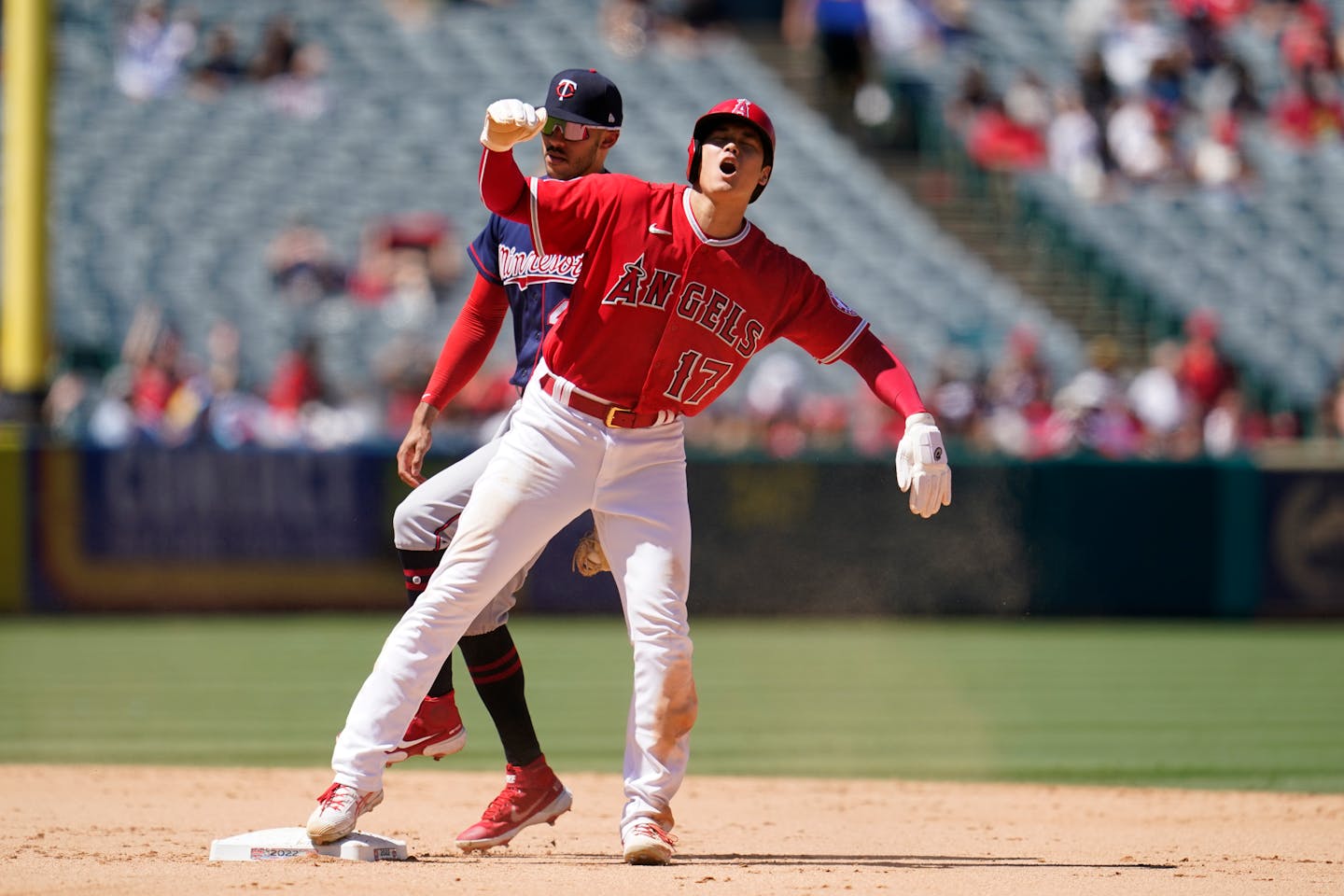 Los Angeles Angels' Shohei Ohtani (17) reacts after being tagged out at second base by Minnesota Twins shortstop Carlos Correa left, on a steal-attempt during the fifth inning of a baseball game Sunday, Aug. 14, 2022, in Anaheim, Calif. (AP Photo/Marcio Jose Sanchez)