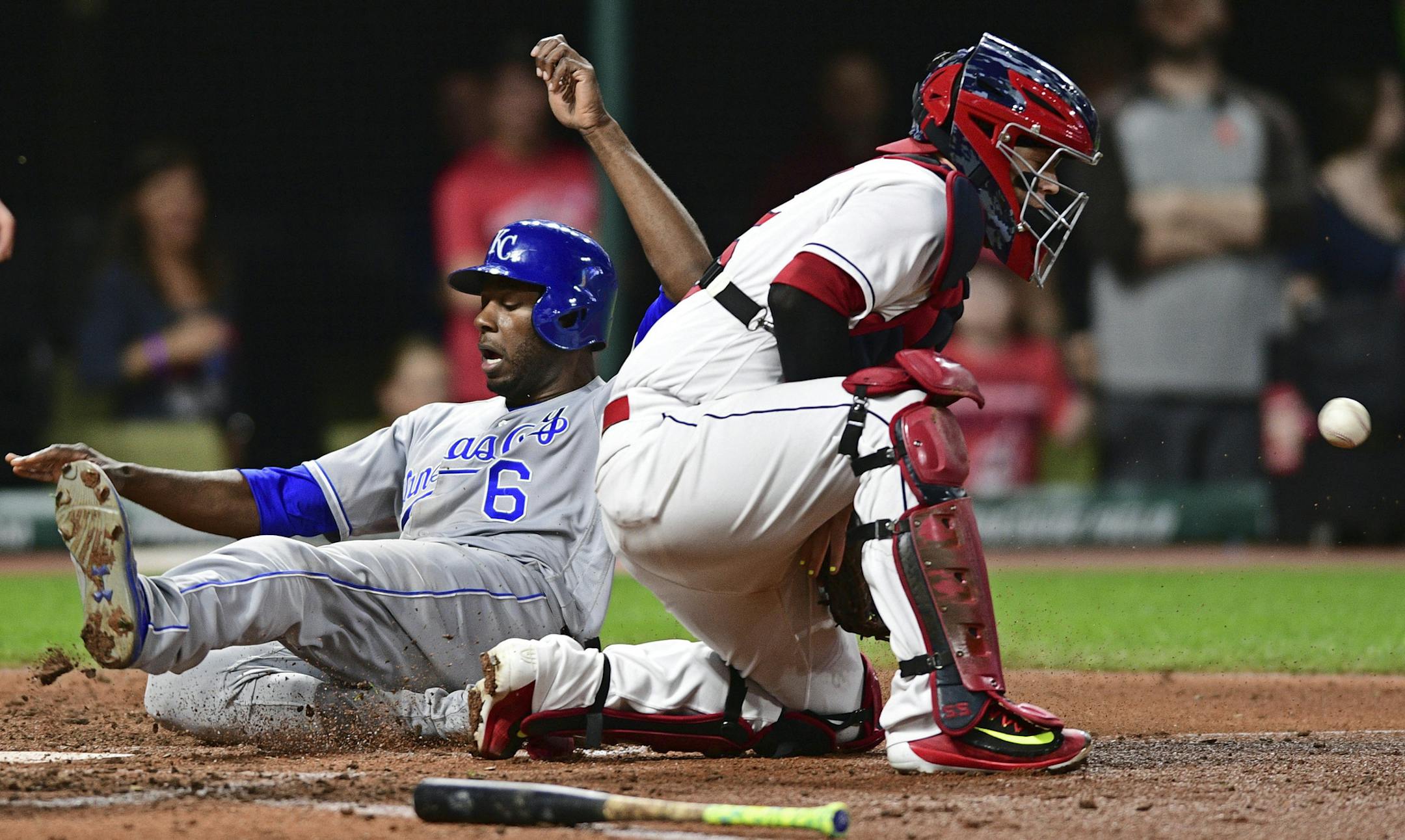 Kansas City Royals' Lorenzo Cain, left, slides safely into home to score on a RBI-single by Eric Hosmer while Cleveland Indians catcher Roberto Perez blocks the ball in the fifth inning of a baseball game, Friday, Sept. 15, 2017, in Cleveland. (AP Photo/David Dermer)