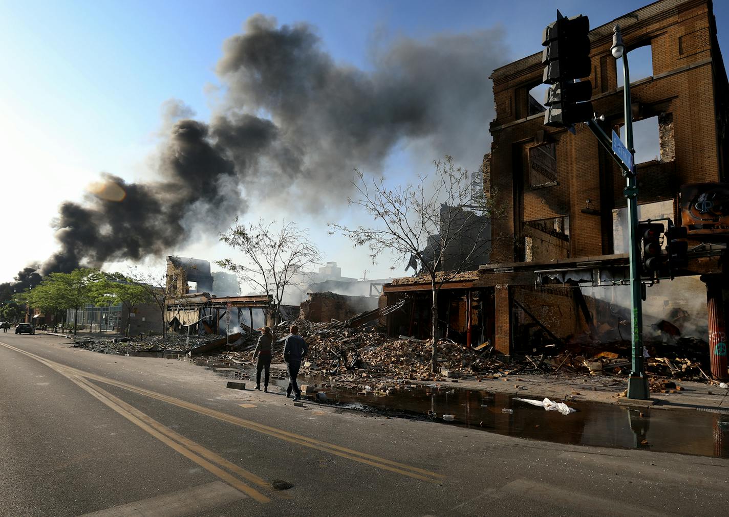 People survey the damage along Lake St. near S. 27th Ave. as a fire burns to the east Saturday, May 30, 2020, in Minneapolis, MN.] DAVID JOLES • david.joles@startribune.com Latest on the death of George Floyd.