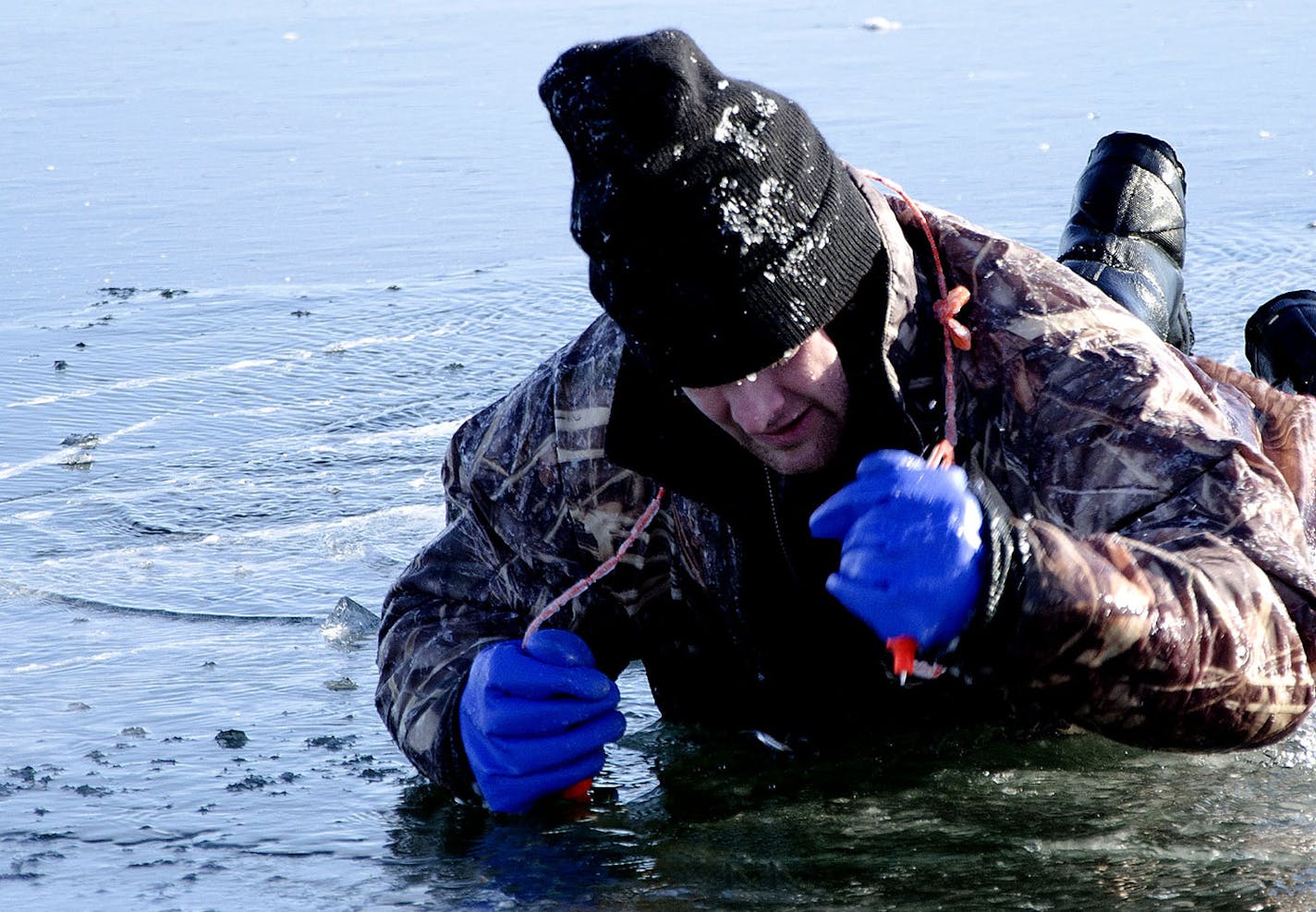 A Cass County Sheriff's Deputy uses ice picks to pull himself out of a hole in the ice as part of a recent ice rescue training exercise for first responders and law enforcement officers. The picks, tied together and sometimes threaded through the arms of a person's jacket, are vital safety equipment recommended for all ice anglers.