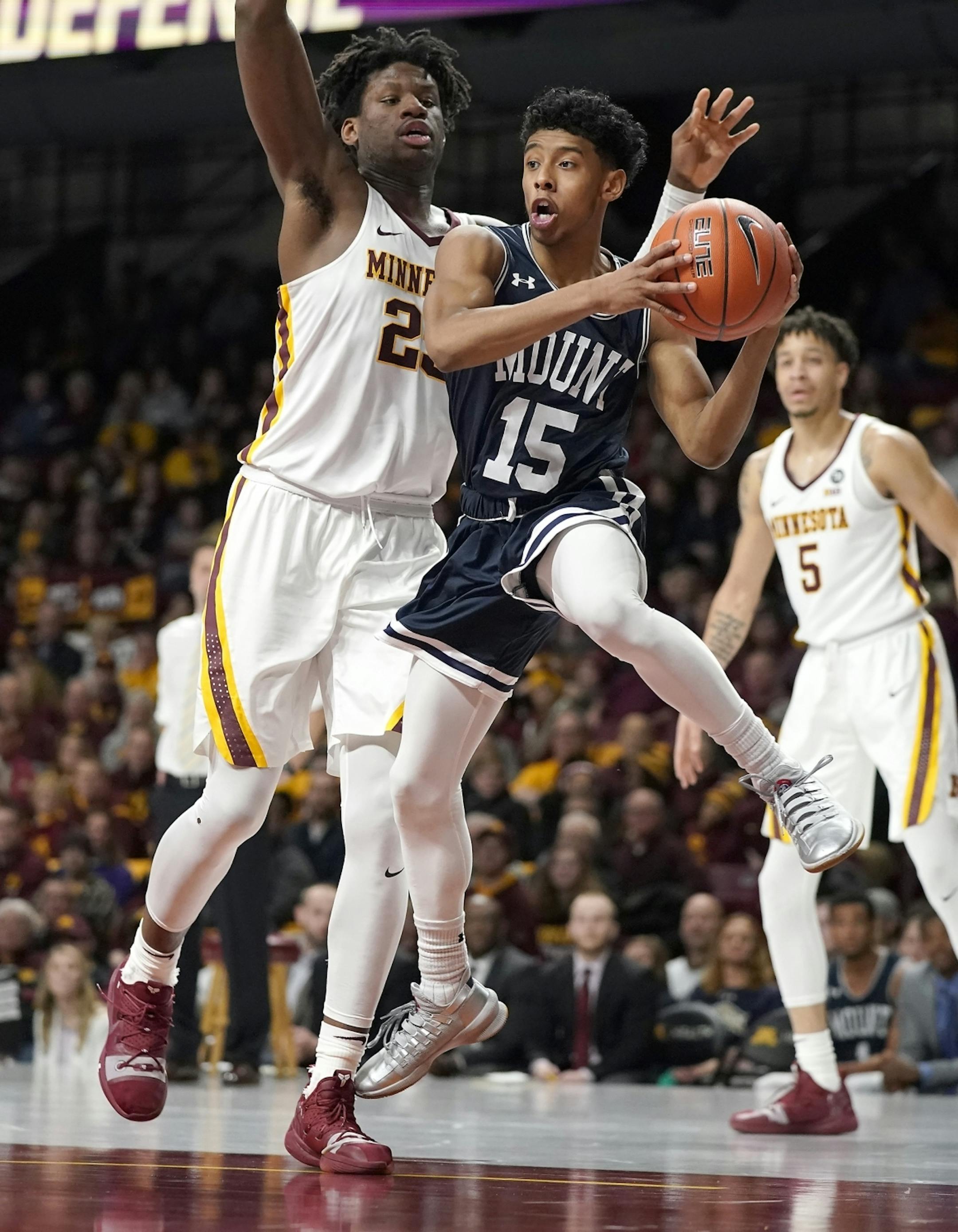 Mount St. Mary's guard Damian Chong Qui (15) looks for a pass under the basketball as Minnesota center Daniel Oturu (25) defends during the second half.