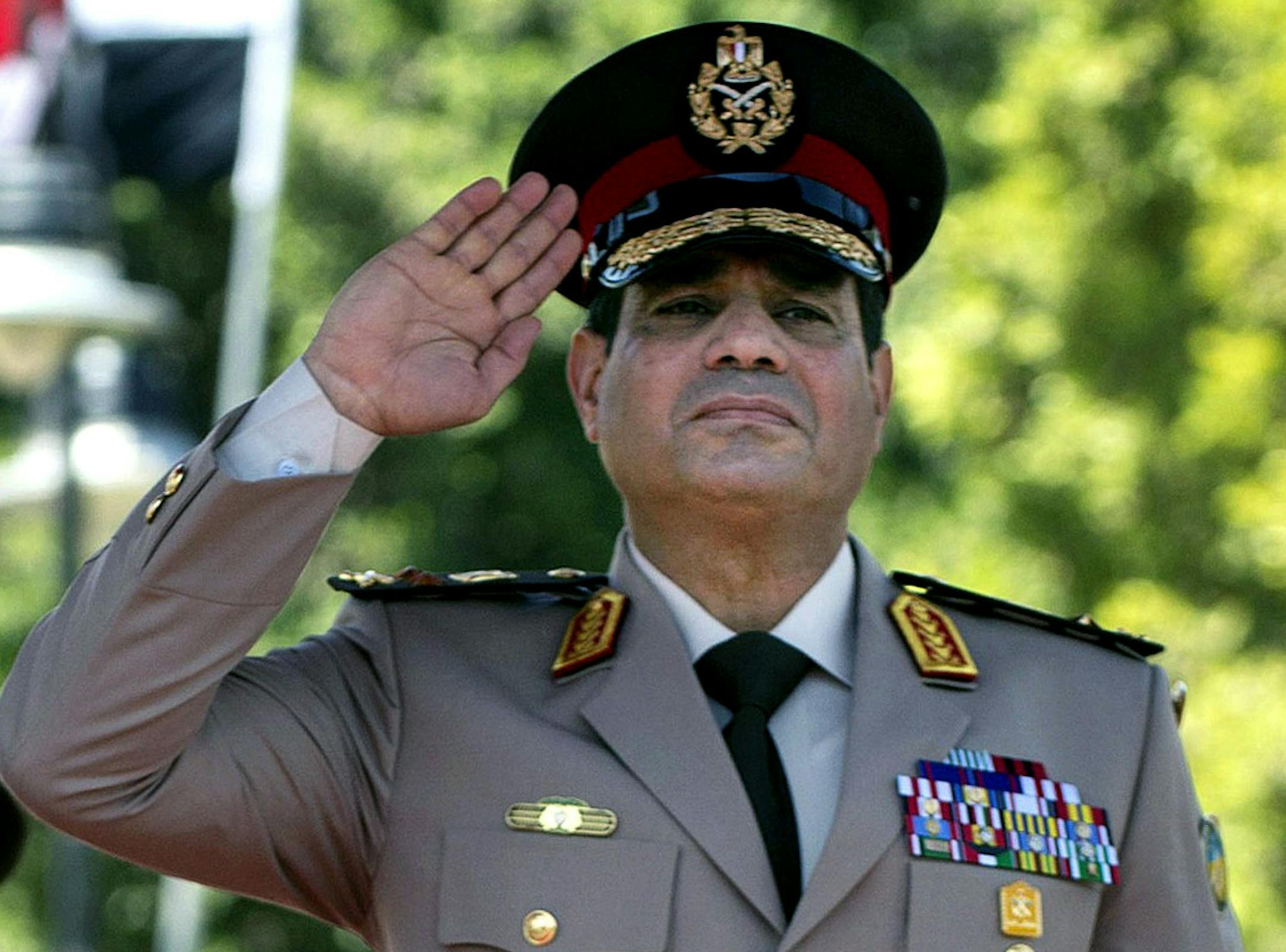 FILE - In this Wednesday, April 24, 2013 file photo, Egyptian Defense Minister Gen. Abdel-Fattah el-Sissi salutes during an arrival ceremony for U.S. Secretary of Defense Chuck Hagel, at the Ministry of Defense in Cairo. Egypt's military chief on Wednesday called on his countrymen to hold mass demonstrations to voice their support for the army and police to deal with potential "violence and terrorism," a move that signals a stepped up campaign against supporters of the ousted Islamist president.