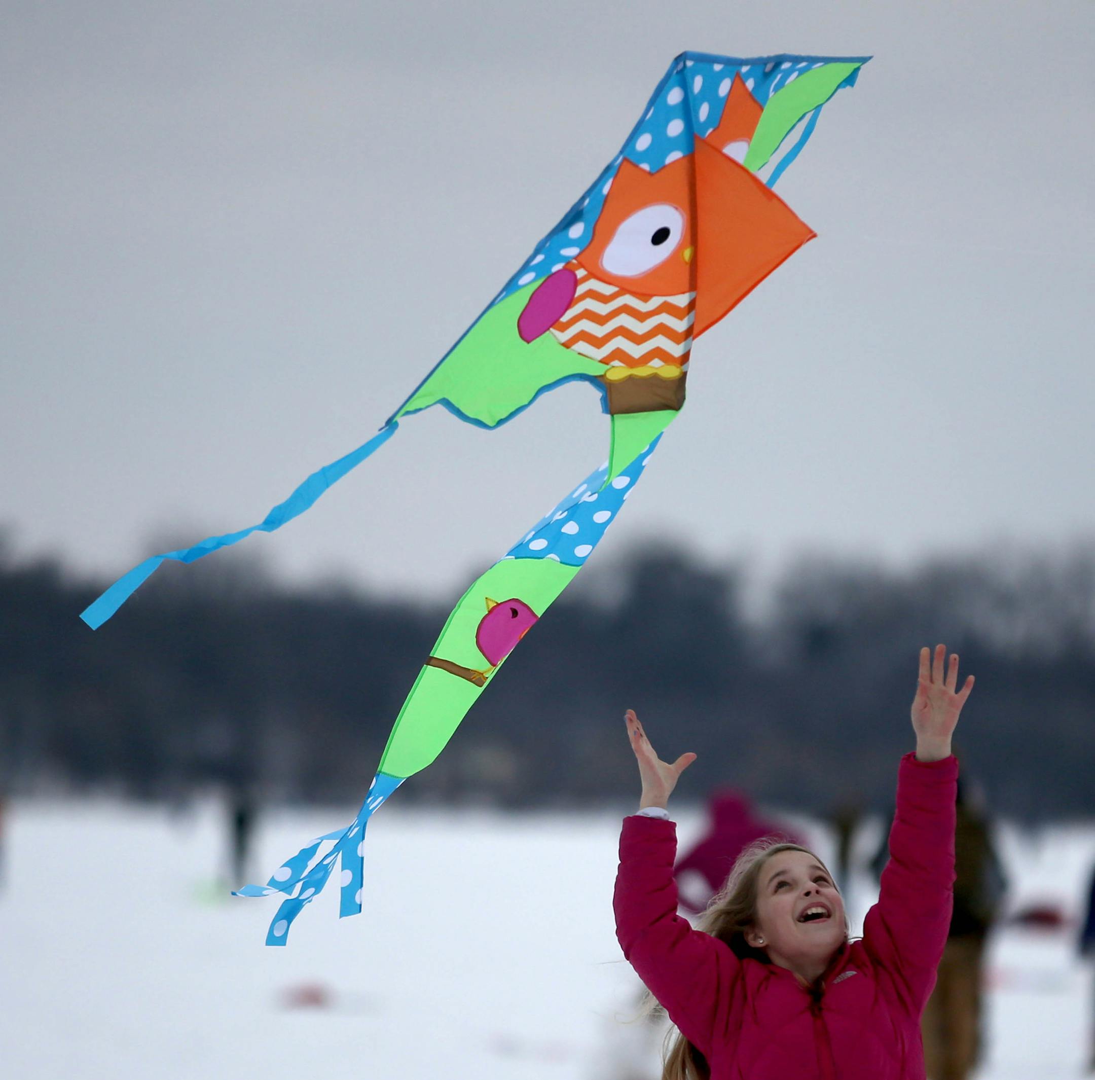 Lindsey Gunderson, 10, of Corcoran, let the wind catch her kite to watch it take off in the air over Lake Harriet. ] (KYNDELL HARKNESS/STAR TRIBUNE) kyndell.harkness@startribune.com 14th Annual Winter Kite Festival at Lake Harriet in Minneapolis Min., Saturday, January 17, 2014.