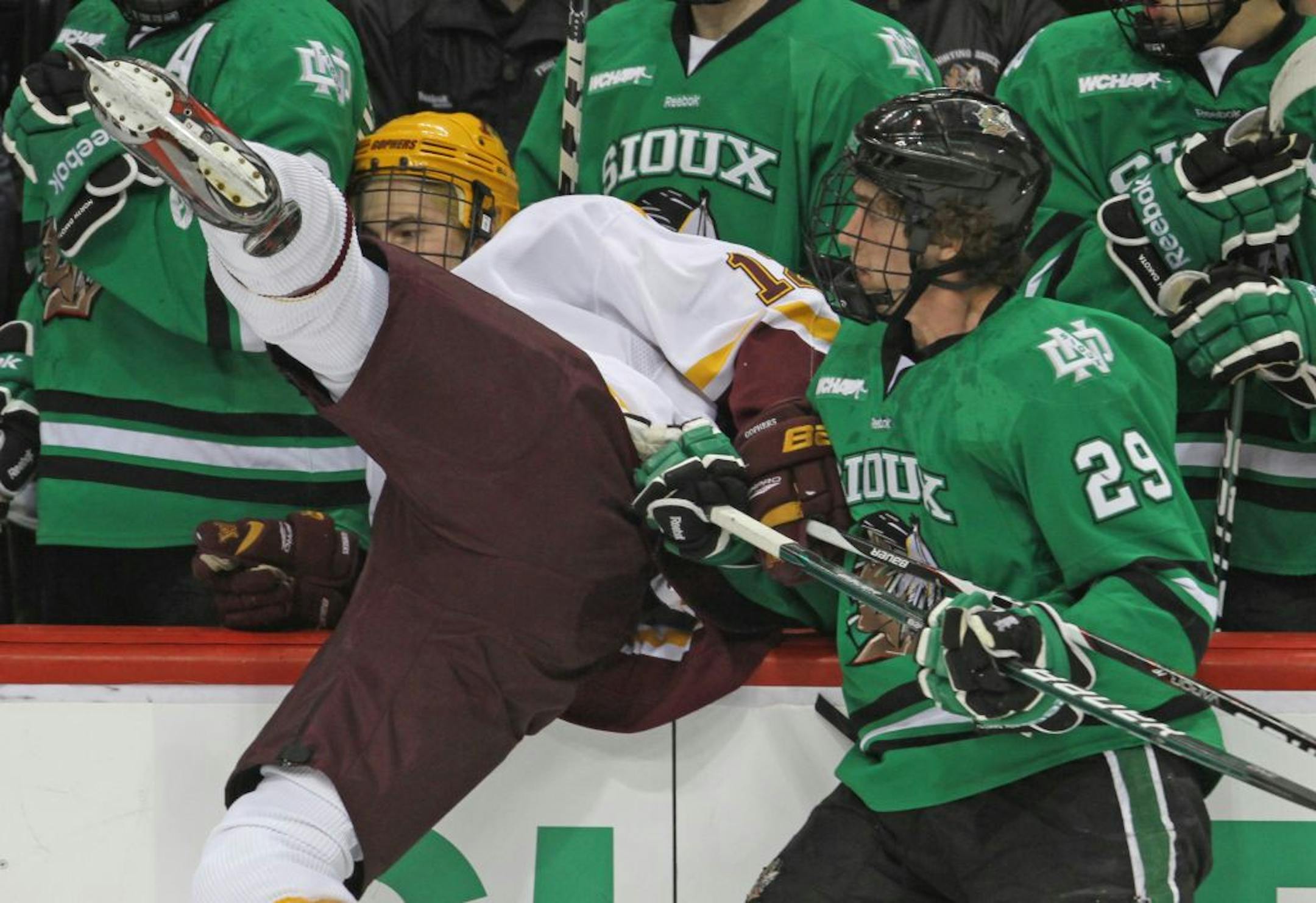 WCHA Frozen Five Semi-Finals, University of Minnesota vs. North Dakota, Xcel Center, 3/16/12. (left to right) Minnesota's Justin Holl was checked into the Sioux bench by North Dakota's Brock Nelson
