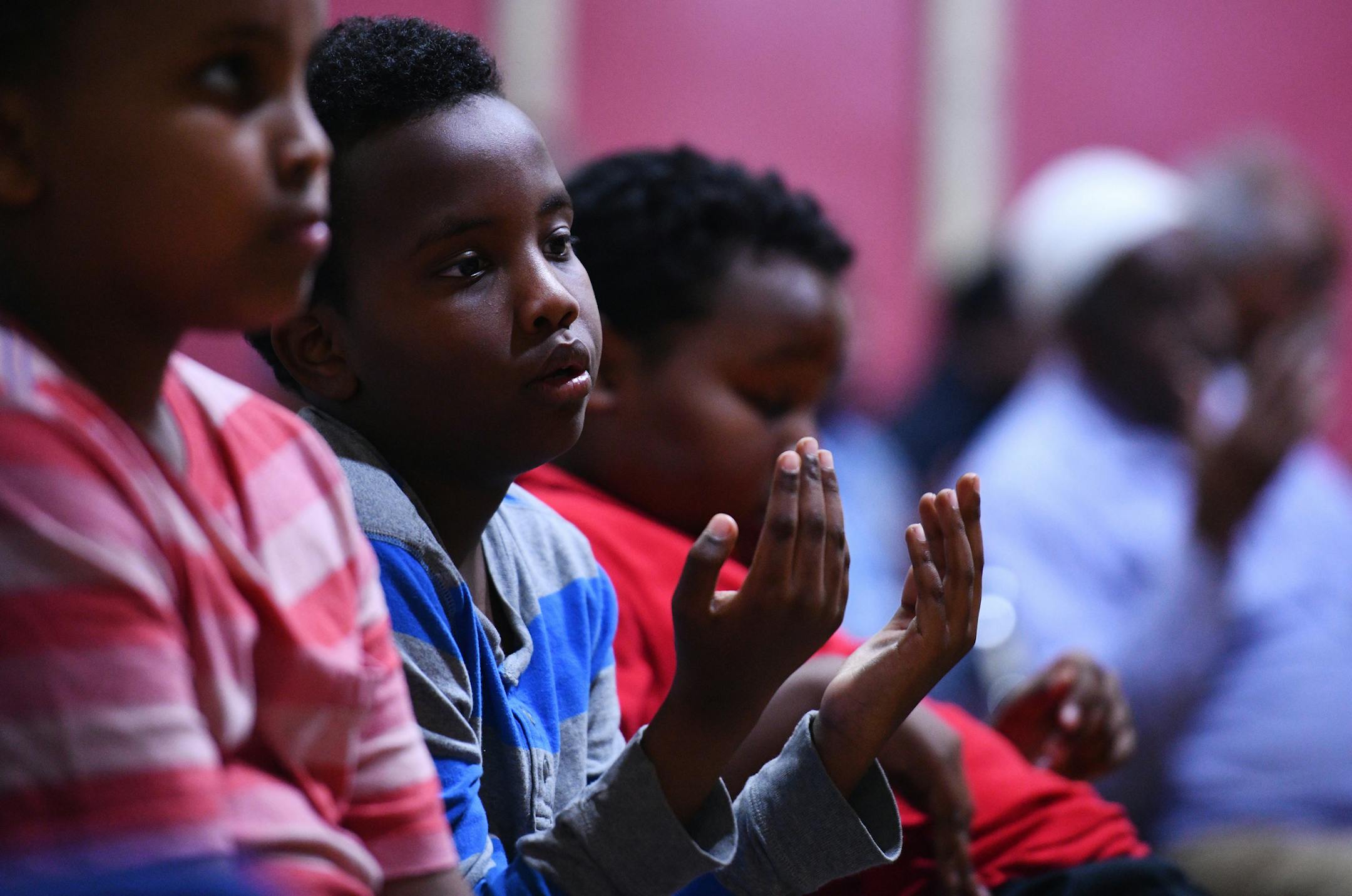 Yahya Eyow, 10, takes part in a prayer at the end of the service for his father. ] MARK VANCLEAVE ï mark.vancleave@startribune.com * Friends and acquaintances from Ahmed Eyow's professional, religious and personal lives gathered at Dar Al Farooq Islamic center to remember the Bloomington father of three who was killed along with over 300 others in a bombing in Mogadishu earlier this month. Photographed Sunday, Oct. 22, 2017.