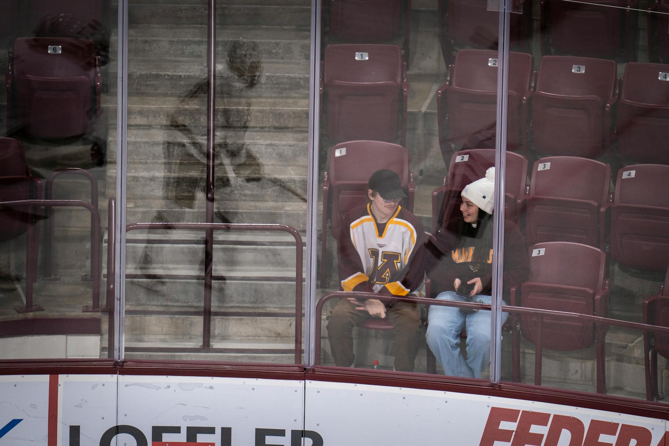 A young couple watches the Minnesota game against Bemidji State University.
