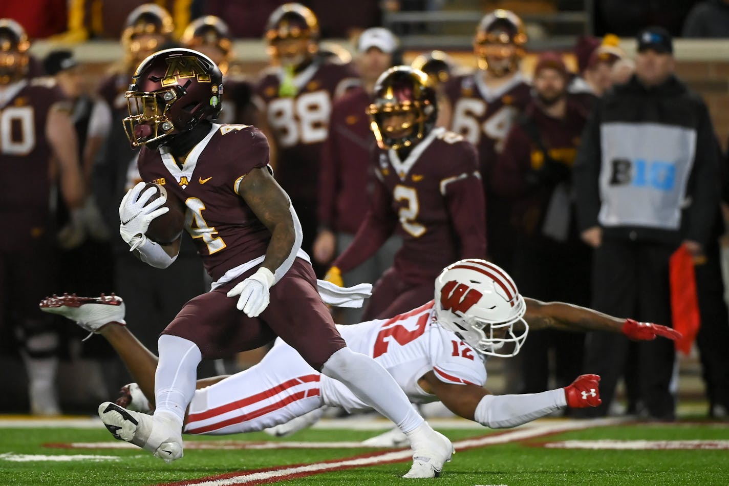 Gophers running back Mar'Keise Irving dodged a tackle by Wisconsin cornerback Max Lofy.