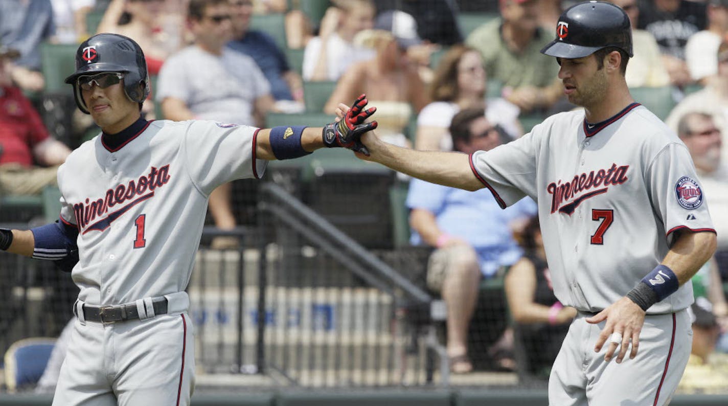 Joe Mauer, right, celebrated with Tsuyoshi Nishioka after scoring on a single by Rene Tosoni during the fifth inning Sunday.