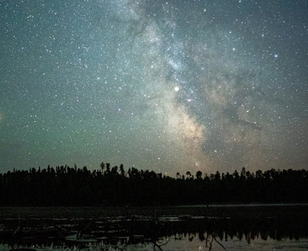 Saturn shines brightly against the backdrop of the Milky Way above Fire Lake in the Boundary Waters Canoe Area.