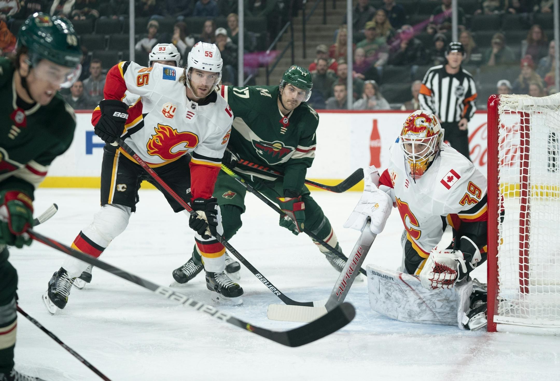 Wild left wing Marcus Foligno (17) watched for a centering pass in front of Calgary goaltender Cam Talbot while defended by Flames defenseman Noah Hanifin last month.