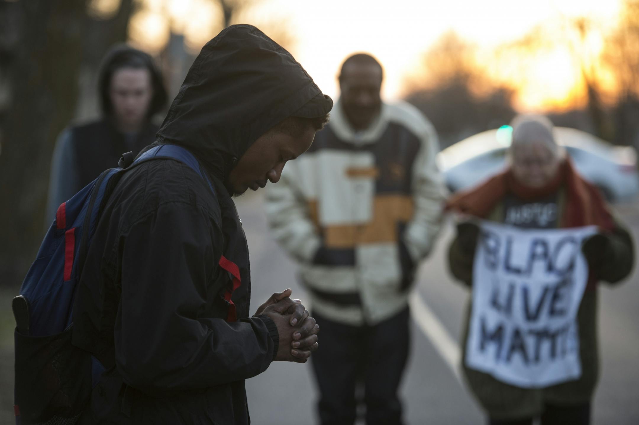 Kendrick Hall, from North Minneapolis, bowed his head in prayer during Friday afternoon's vigil. Hall is friends with Jamar Clark's cousin, Alexander.