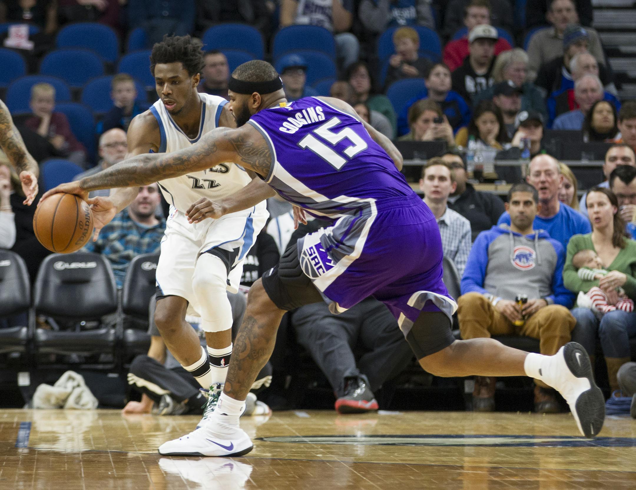 Minnesota Timberwolves forward Andrew Wiggins (22) and Sacramento Kings forward DeMarcus Cousins (15) go for a loose ball during the first half of an NBA basketball game, Friday, Dec. 23, 2016, in Minneapolis. (AP Photo/Paul Battaglia)