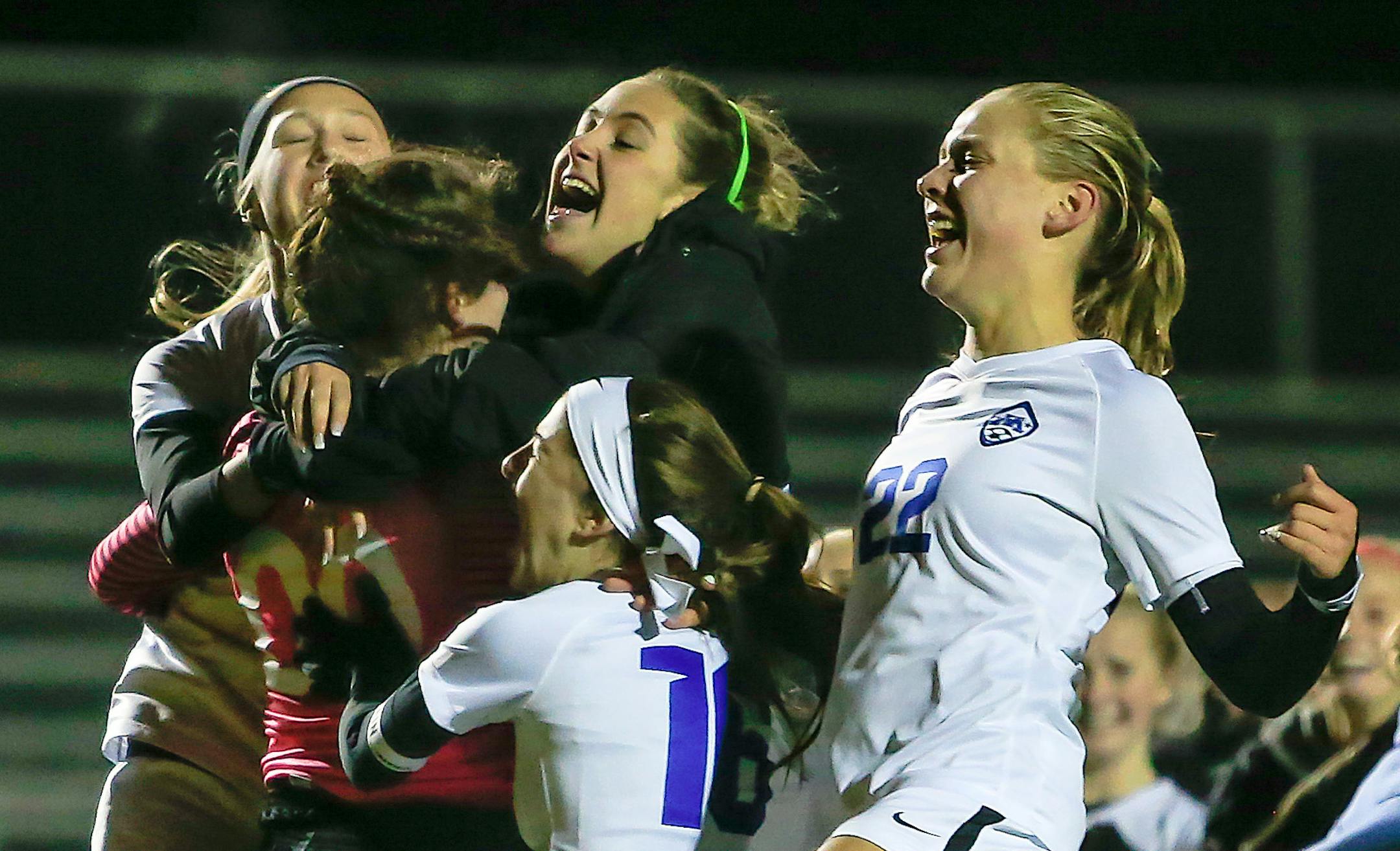 Minnetonka players led by Riley Brackin (22) rushed to congratulate goaltender Paige Kahlmeyer (00) after she stopped the final shot in an overtime shootout against Maple Grove in a girls' soccer state tournament quarterfinal at Prior Lake. The Skippers won 2-1 in the shootout. Brackin scored the Skippers' first-half goal. Photo by Mark Hvidsten, SportsEngine