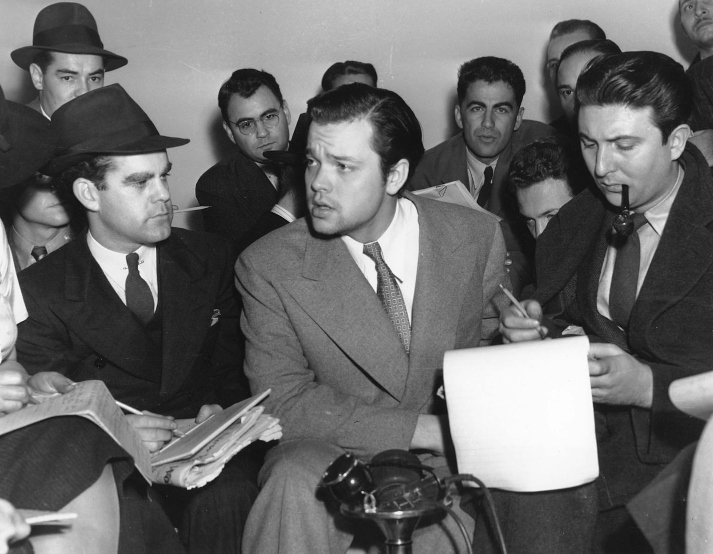 Orson Welles, center, explains to reporters on Oct. 31, 1938 his radio dramatization of H.G. Wells' "War of the Worlds." Meanwhile, Columbia Broadcasting System made public the transcript of the dramatization, which was aired the night of Oct. 30 and caused thousands of listeners to panic because of the realistic broadcast of an imaginative invasion of men and machines from Mars. (AP Photo) ORG XMIT: APHS104