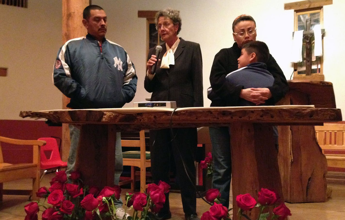 This Thursday, Nov. 20, 2014 photo shows Rosa Robles Loreto, right, hugs her 8-year-old son, Jose Emiliano, at Southside Presbyterian Church with Margo Cowan and Gerardo Grijalva Noriega, left, in Tucson, Ariz. while addressing the media following the announcement by President Barack Obama regarding executive action to shield up to 5 million immigrants who live in the country illegally from deportation. Robles Loreto will not qualify for the new program because her two sons are not American citi
