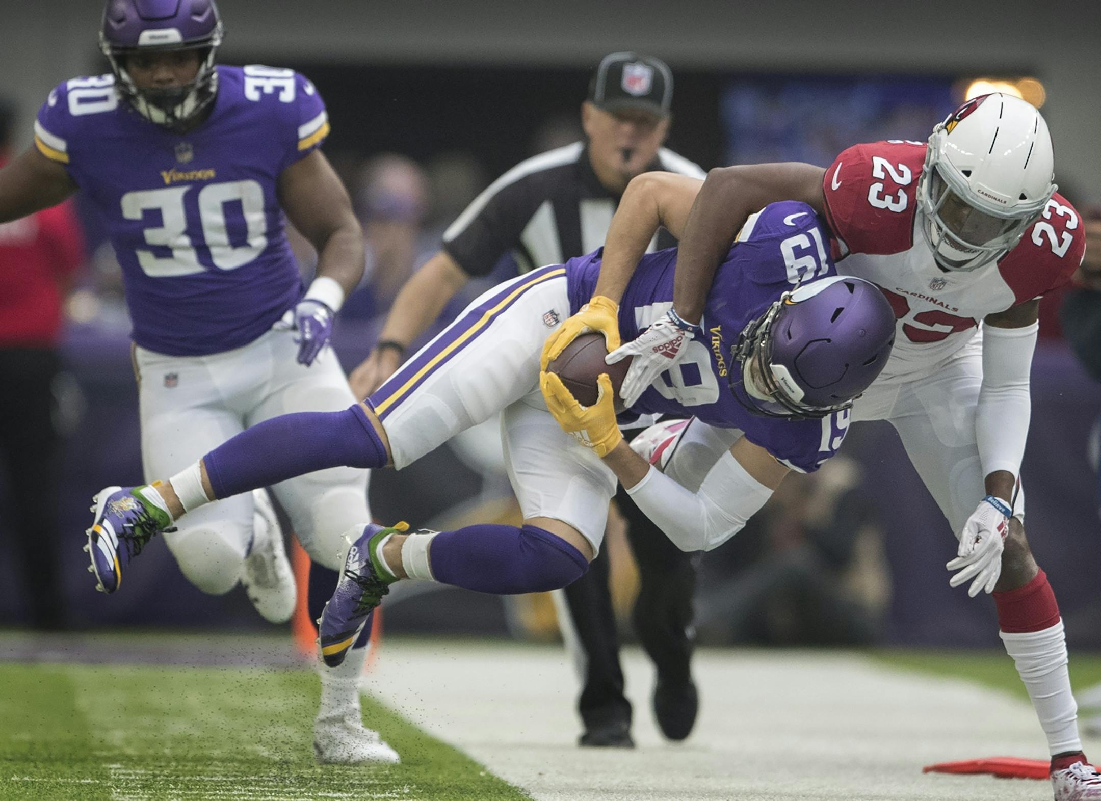 Minnesota Vikings wide receiver Adam Thielen (19) was tackled by Arizona Cardinals defensive back Bene' Benwikere (23) after picking up a first down in the first quarter at U.S. Bank Stadium Sunday October 14, 2018 in Minneapolis, MN.