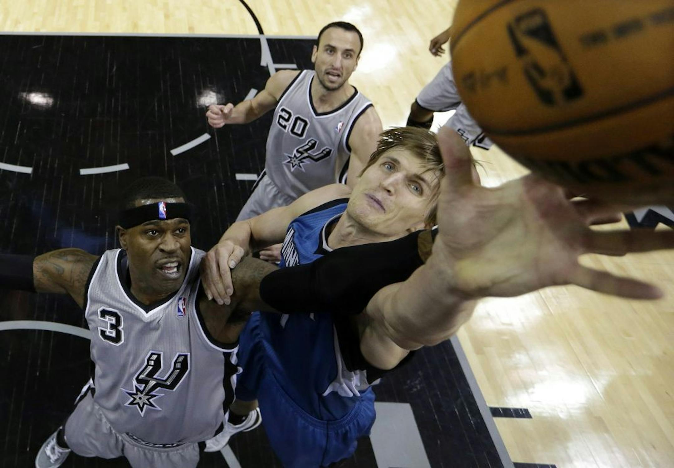 San Antonio Spurs' Stephen Jackson, left, and Minnesota Timberwolves' Andrei Kirilenko, right, of Russia, reach for a rebound and Spurs' Manu Ginobili (20) looks on during the second quarter of an NBA basketball game on Sunday, Jan. 13, 2013, in San Antonio.
